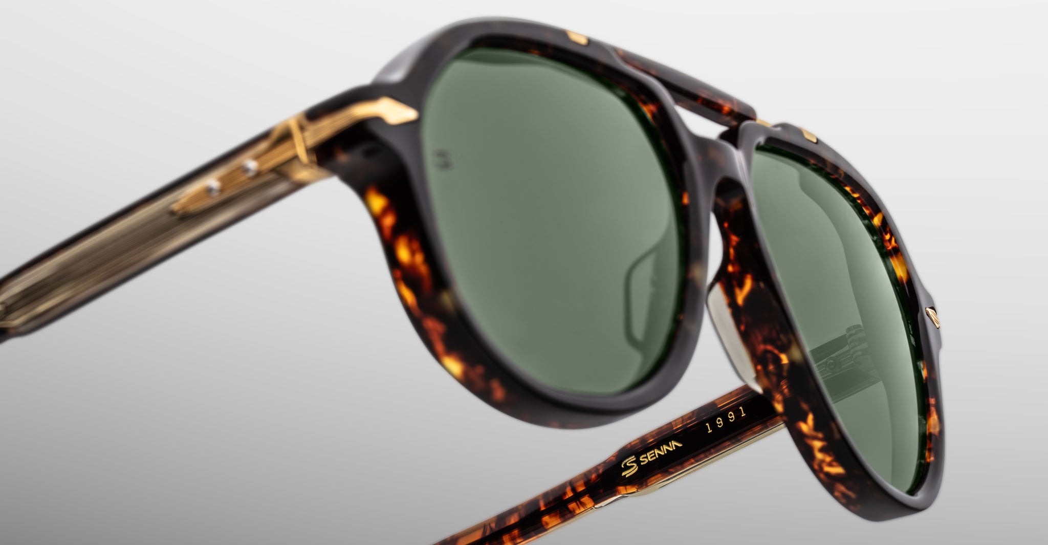 Close-up of Jacques Marie Mage 1991 sunglasses, tortoiseshell frame, green polarized lenses, and gold accents.