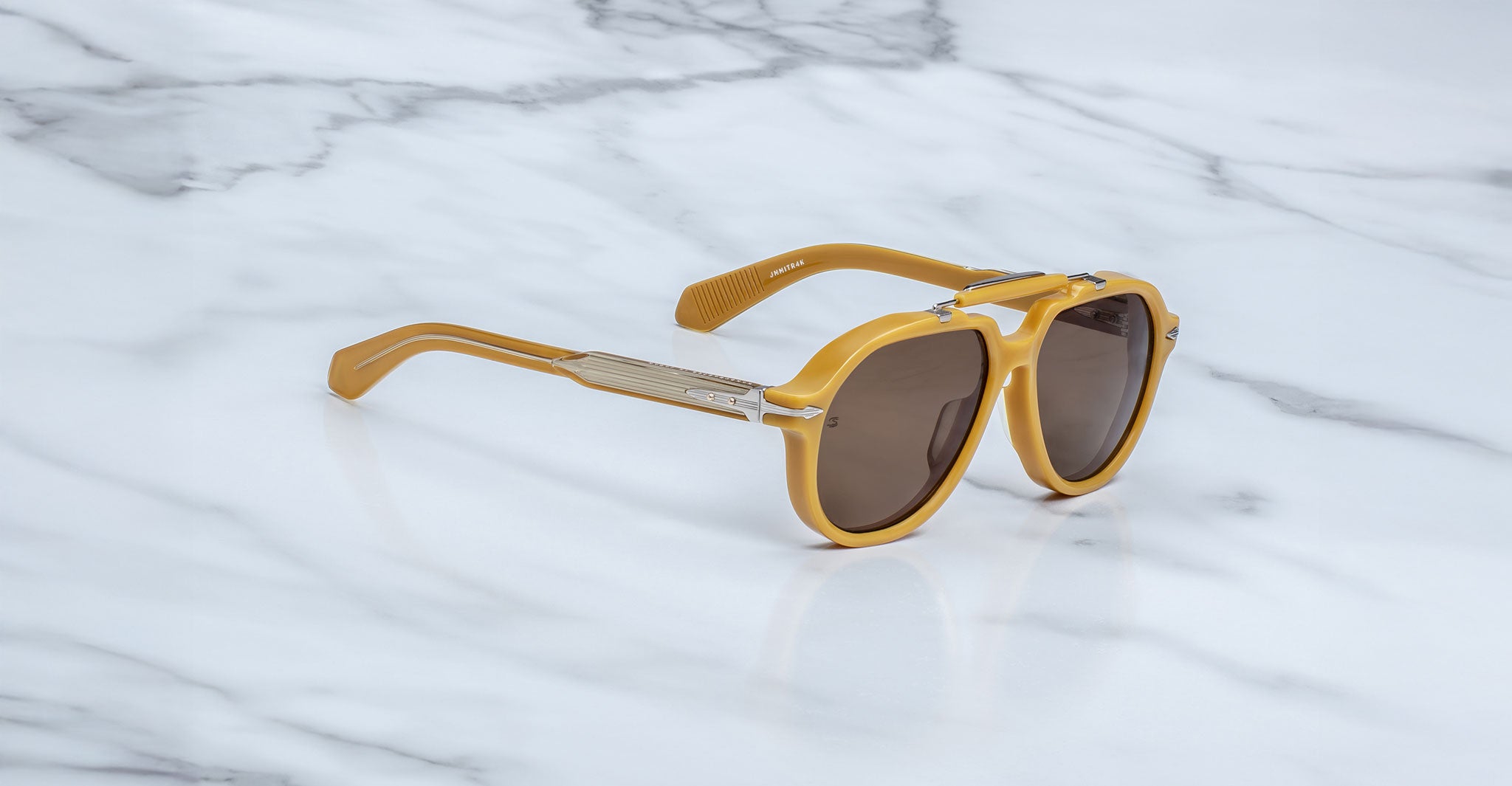Jacques Marie Mage 1991 sunglasses with yellow frames and brown lenses, viewed from above.