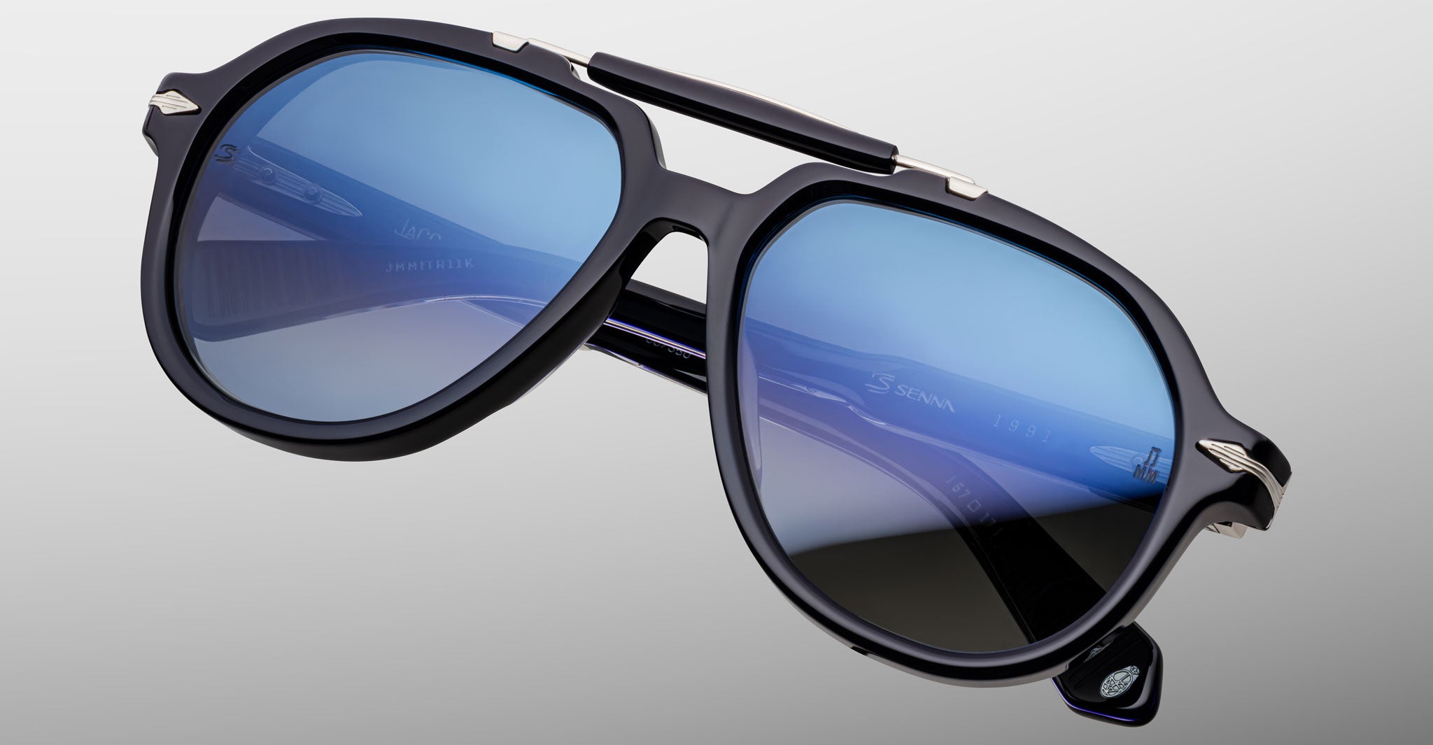 Close-up of Jacques Marie Mage 1991 black sunglasses, blue-tinted lenses, and silver accents, front view.