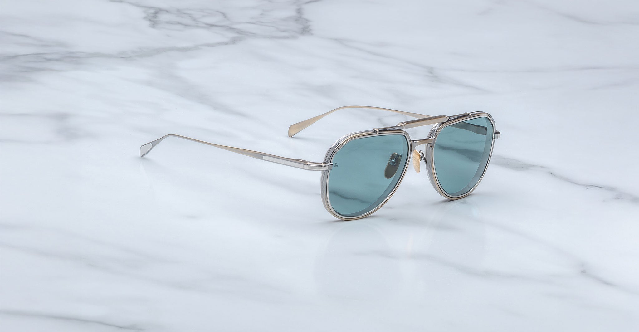Jacques Marie Mage 755M silver aviator sunglasses with blue lenses, angled view.