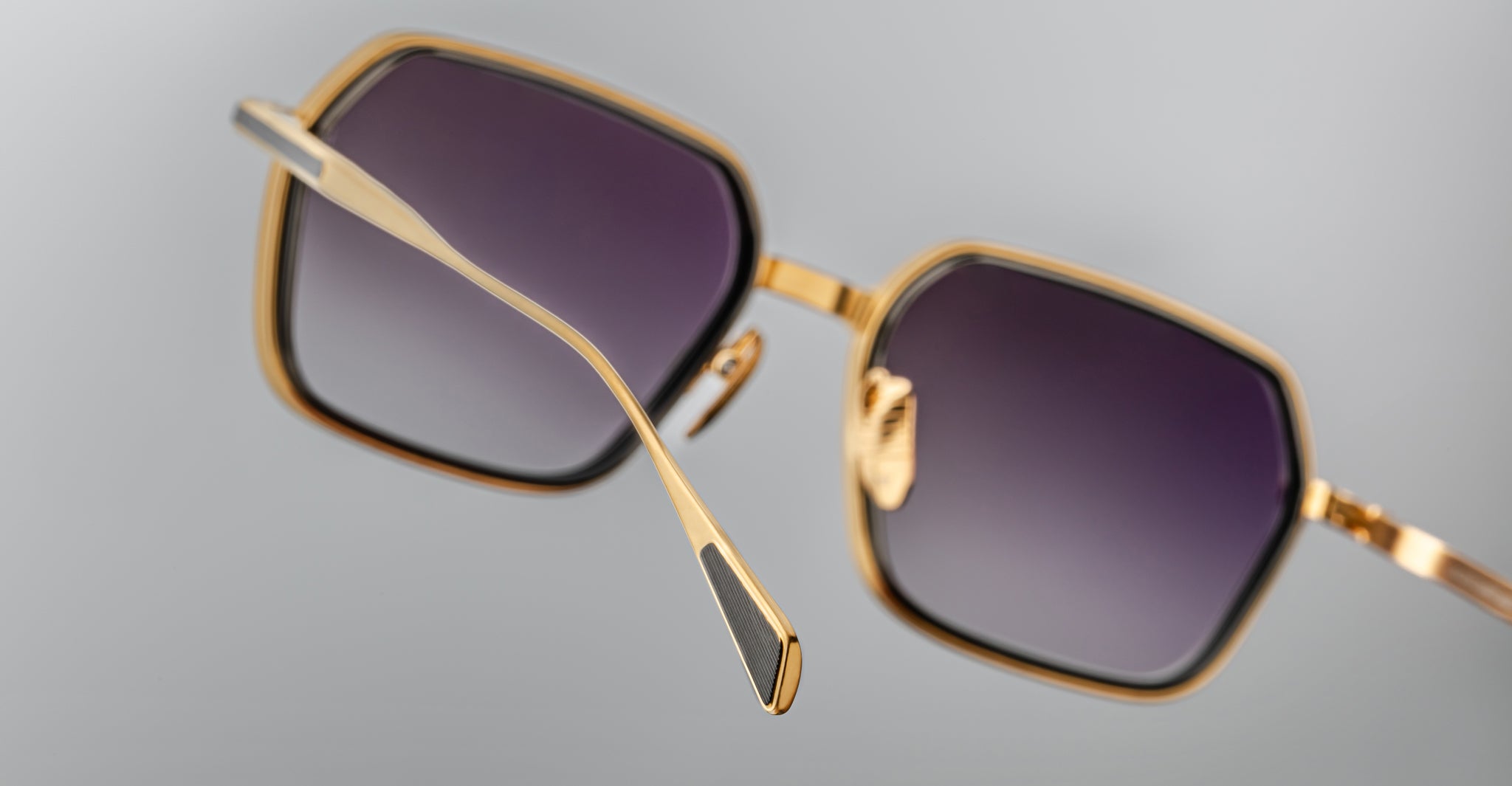 Close-up of Jacques Marie Mage Admiral square sunglasses with gold metal frames and gradient dark lenses, front angle.