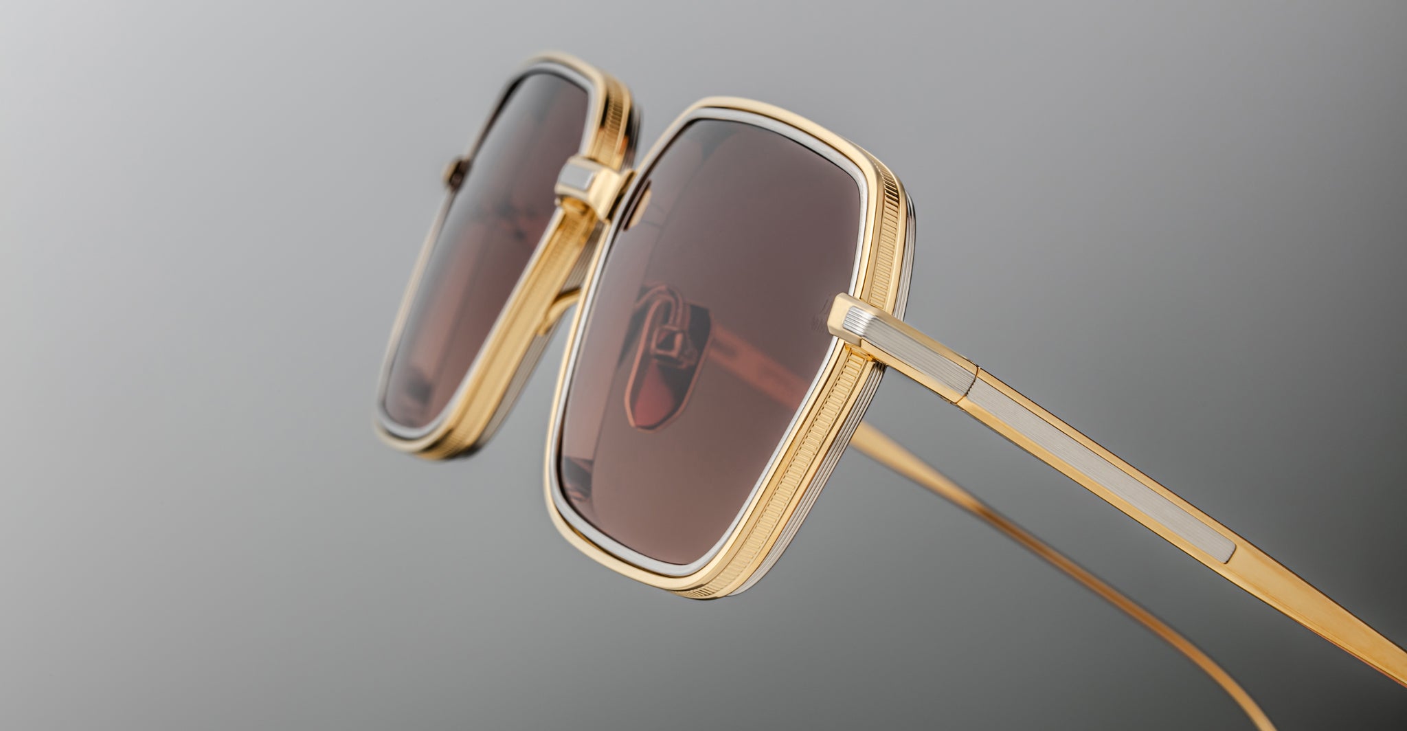 Close-up of Jacques Marie Mage Admiral sunglasses, gold square frames with brown lenses, frontal view.