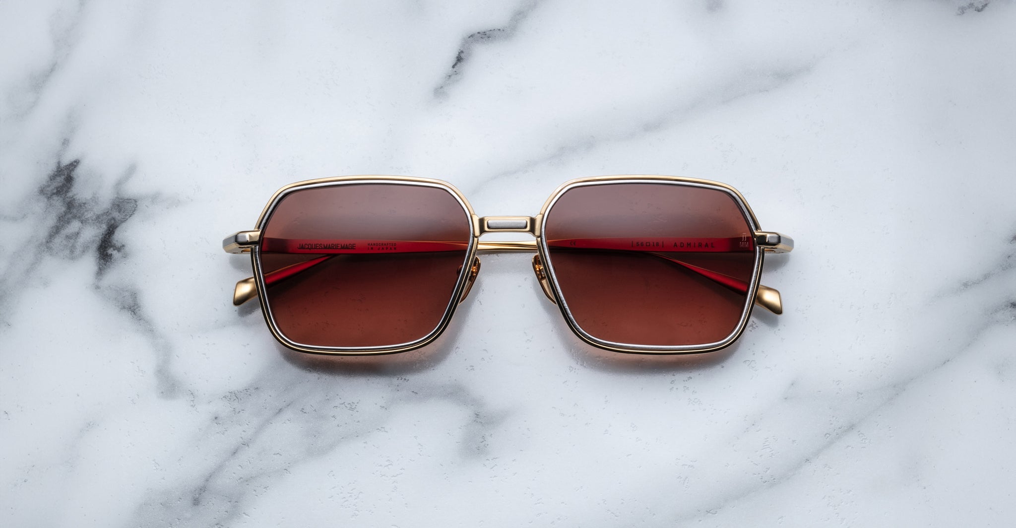 Jacques Marie Mage Admiral sunglasses with gold frames and brown UV lenses, top view.