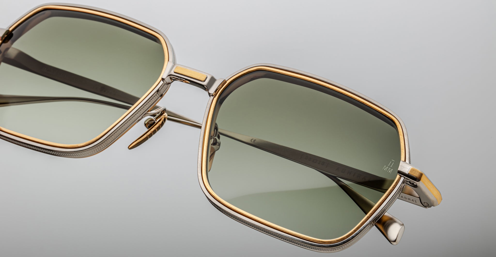 Close-up of Jacques Marie Mage Admiral gold square sunglasses with green-tinted lenses, front view.