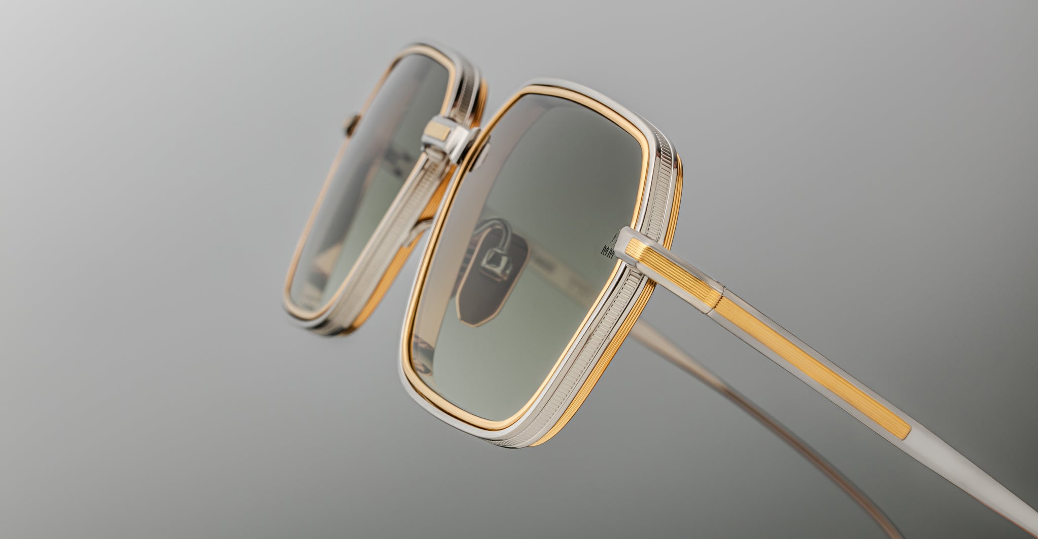 Close-up of Jacques Marie Mage Admiral sunglasses, gold square rims and green tinted lenses, front angle.