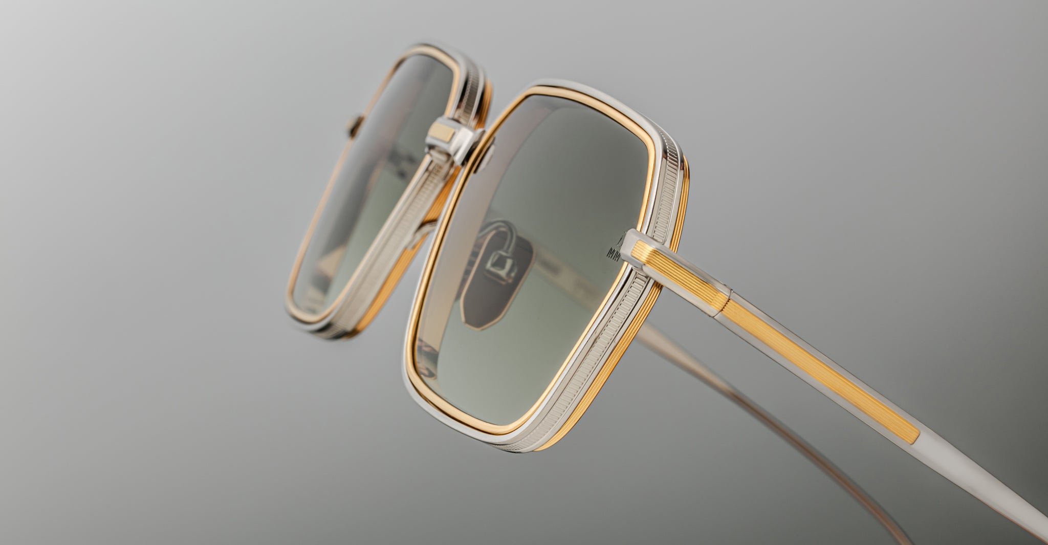 Close-up of Jacques Marie Mage Admiral sunglasses, gold square rims and green tinted lenses, front angle.