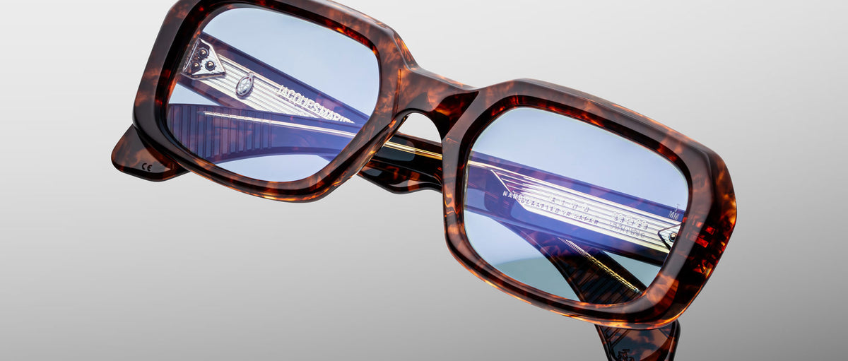 Jacques Marie Mage Aldo square eyeglasses with blue-tinted lenses shown from the front.