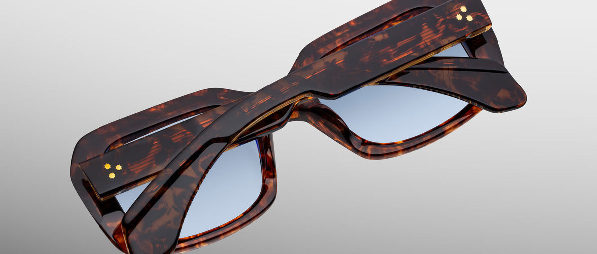 Jacques Marie Mage Aldo sunglasses with twisted tortoiseshell frame and light blue lenses, shown from a front angle.