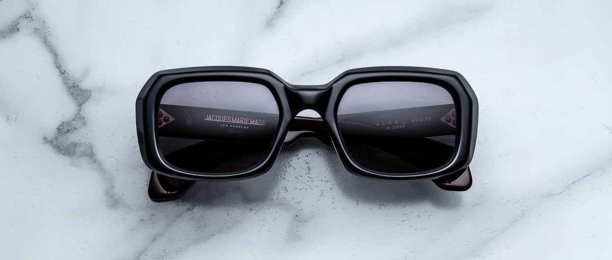 Jacques Marie Mage Aldo sunglasses with dark polarized lenses seen from above, displayed on a flat surface.