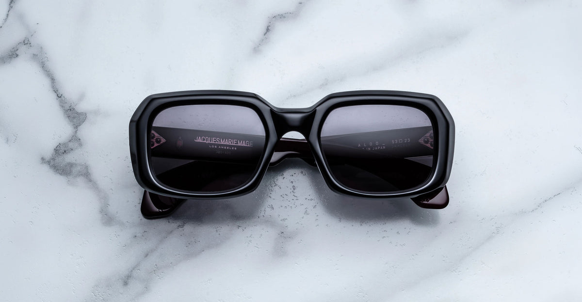 Jacques Marie Mage Aldo sunglasses with dark polarized lenses seen from above, displayed on a flat surface.