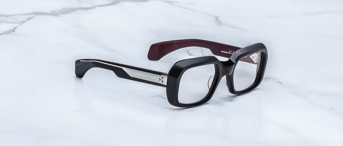 Jacques Marie Mage Aldo black square eyeglasses with maroon inner arms, top-down view.