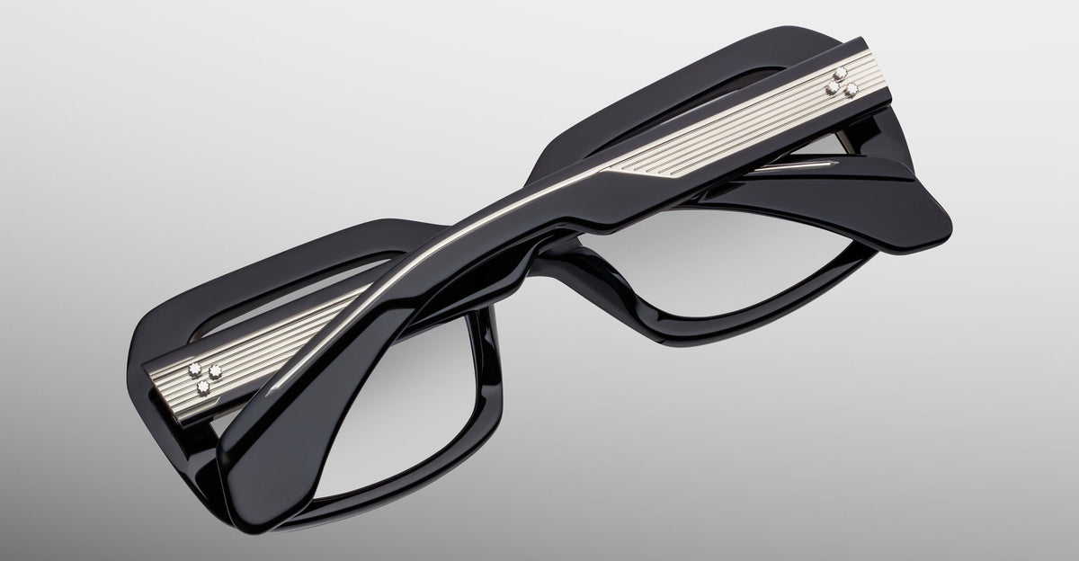 Jacques Marie Mage Aldo eyeglasses, black thick rectangular frames, twisted bridge, metallic temple accents, front view.