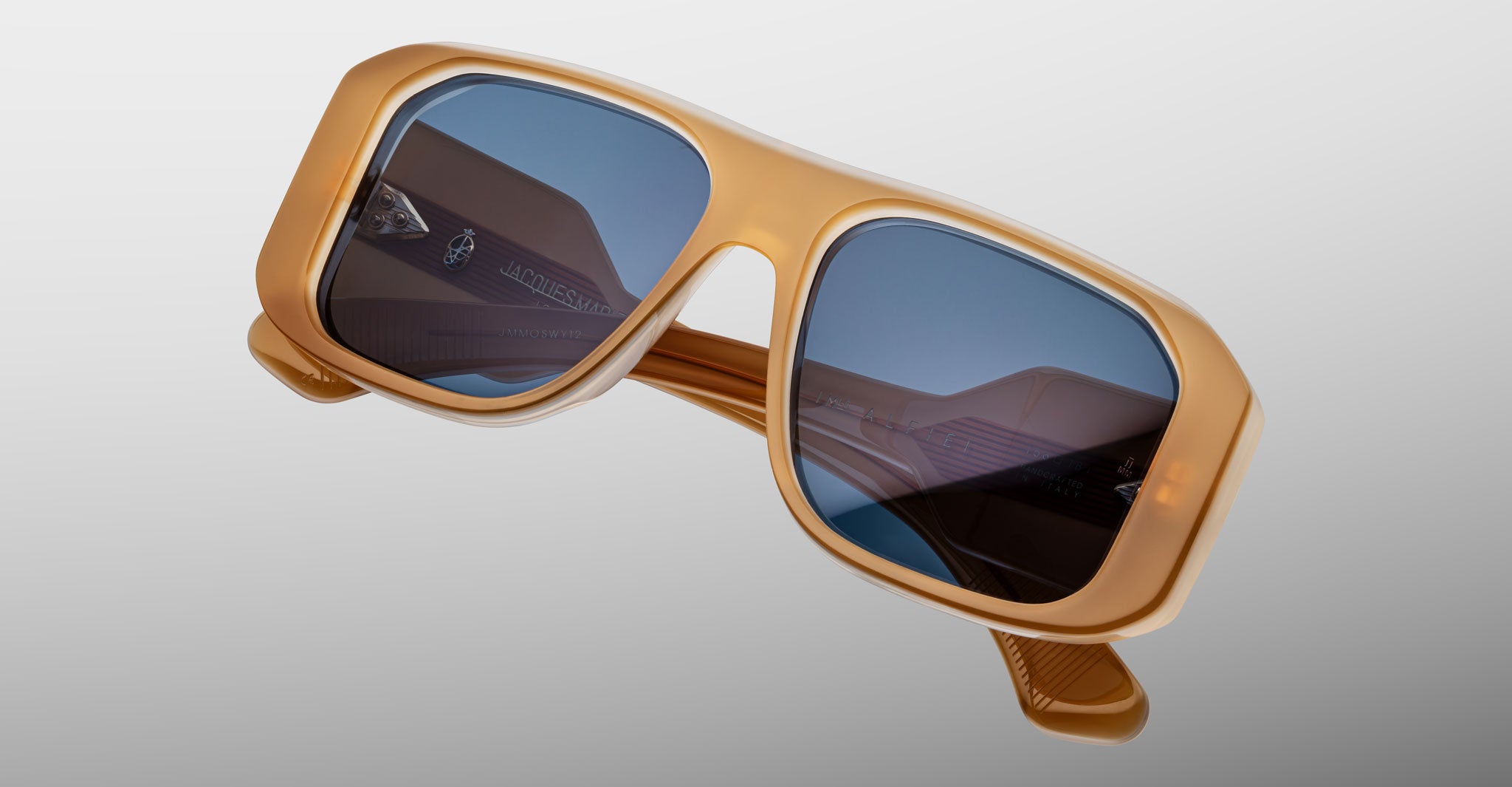 Jacques Marie Mage Alfie sunglasses with square, thick amber frames and blue lenses, shown from the front.