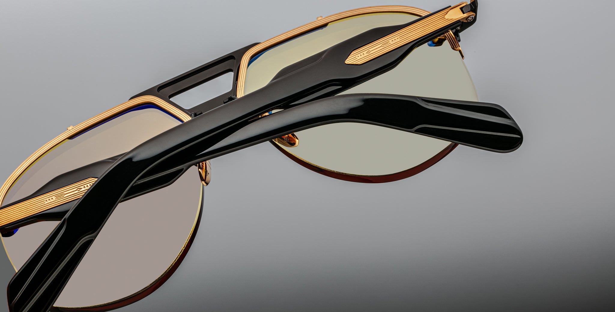 Close-up of Jacques Marie Mage Alta sunglasses, gold and black frame with tinted lenses, front angle.