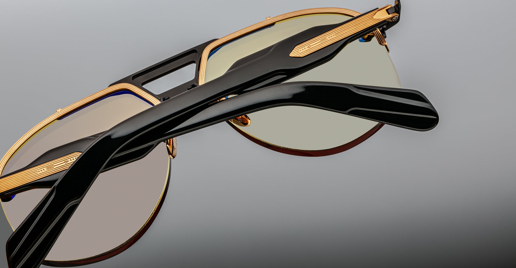 Close-up of Jacques Marie Mage Alta sunglasses, gold and black frame with tinted lenses, front angle.
