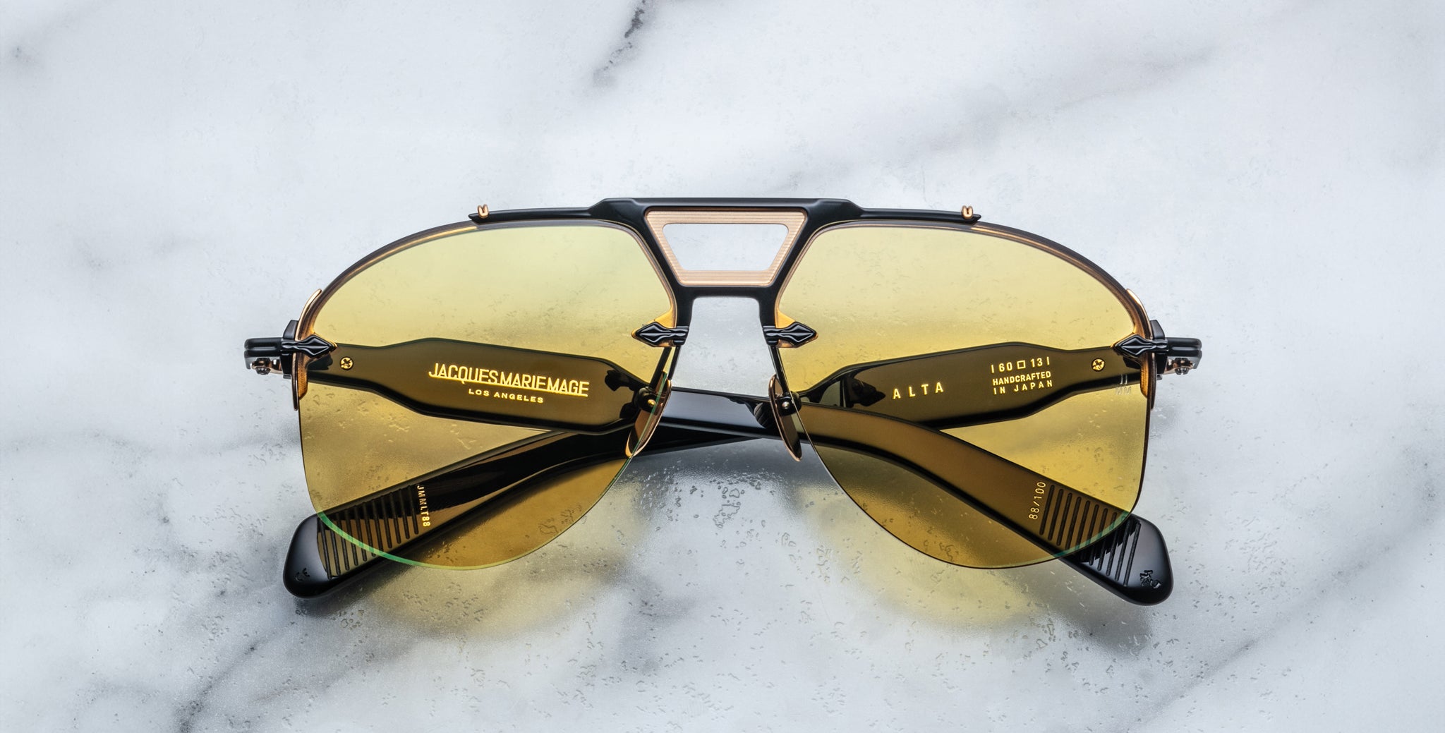 Jacques Marie Mage Alta gold aviator sunglasses with yellow lenses, shown from above.