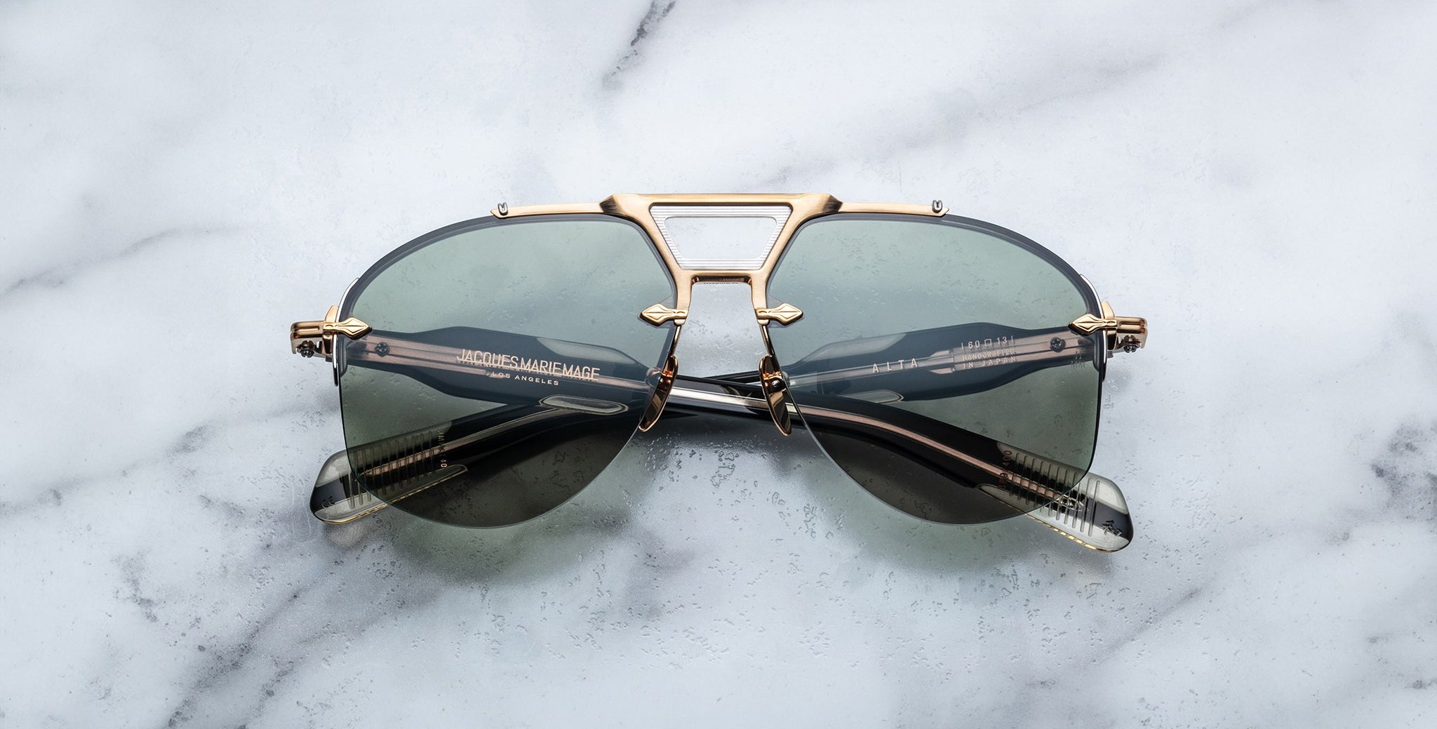 Jacques Marie Mage Alta sunglasses in gold and black, front view, with cat-eye frame design clearly visible.