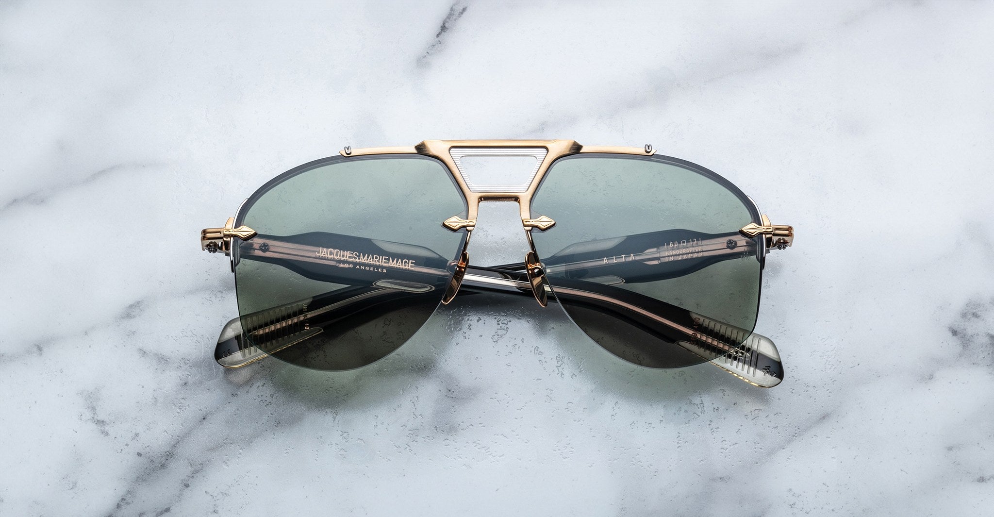 Jacques Marie Mage Alta sunglasses in gold and black, front view, with cat-eye frame design clearly visible.