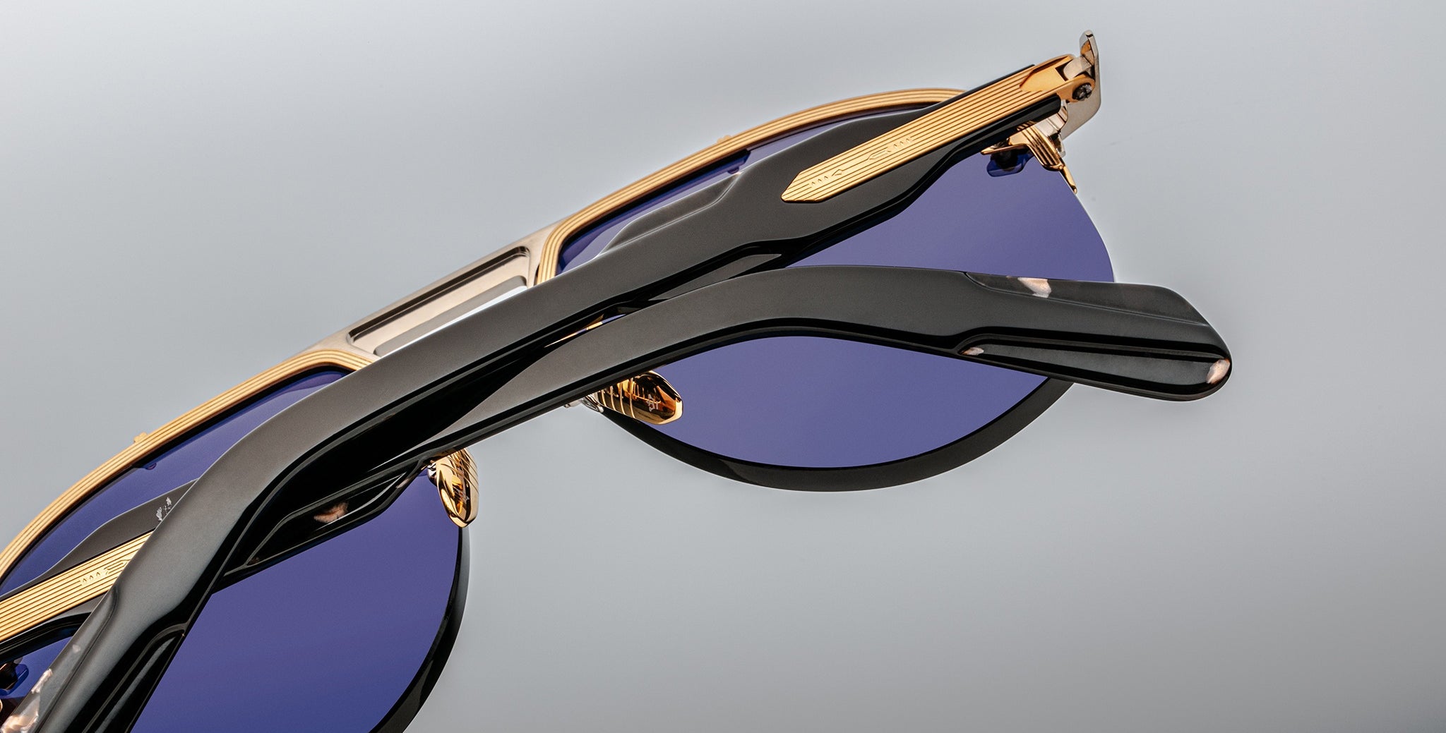 Jacques Marie Mage Alta aviator sunglasses with blue lenses, gold accents, and black arms, front view.