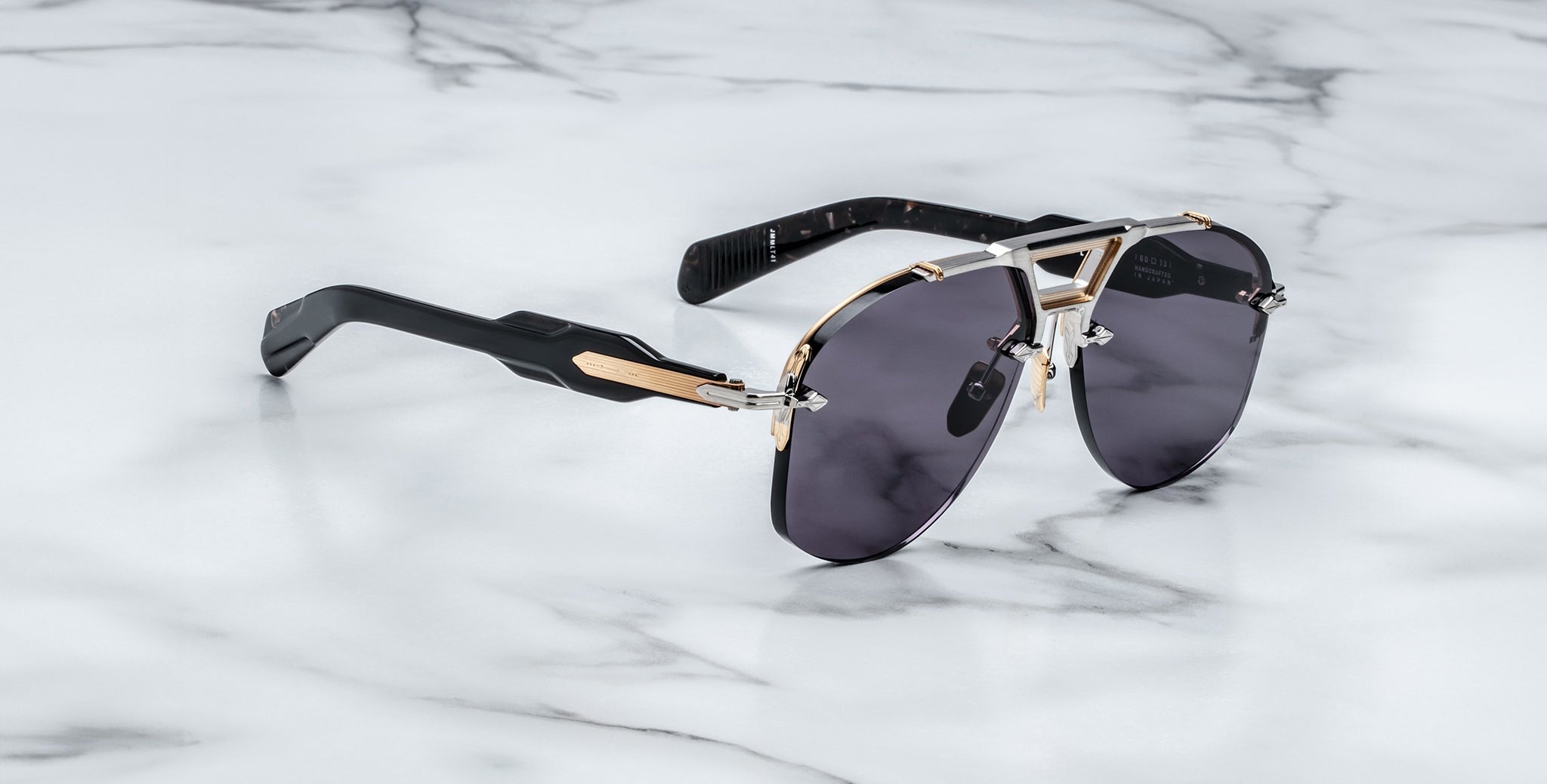 Jacques Marie Mage Alta aviator sunglasses, black and gold frame with dark lenses, shown from above.