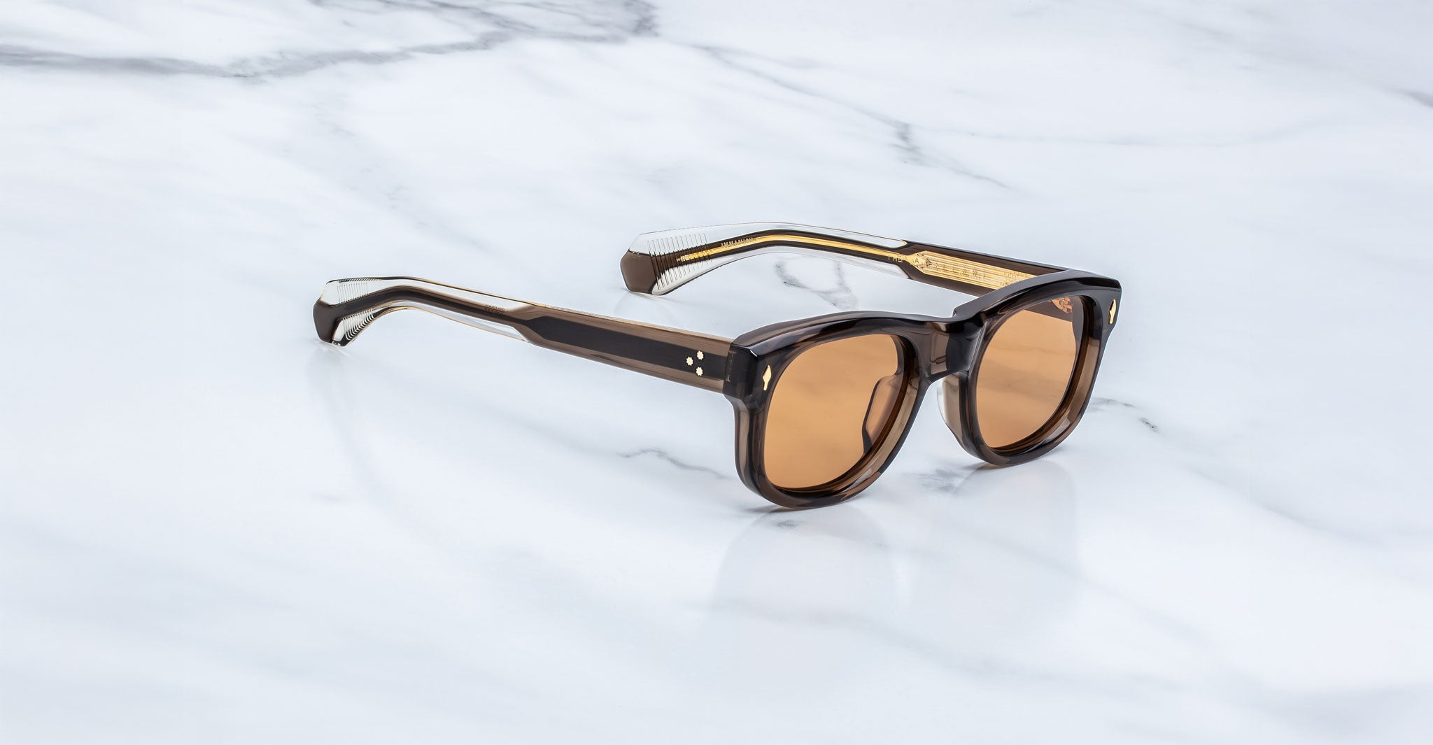 Jacques Marie Mage Amilcar sunglasses with thick dark frames and brown polarized lenses, shown from a front angle.