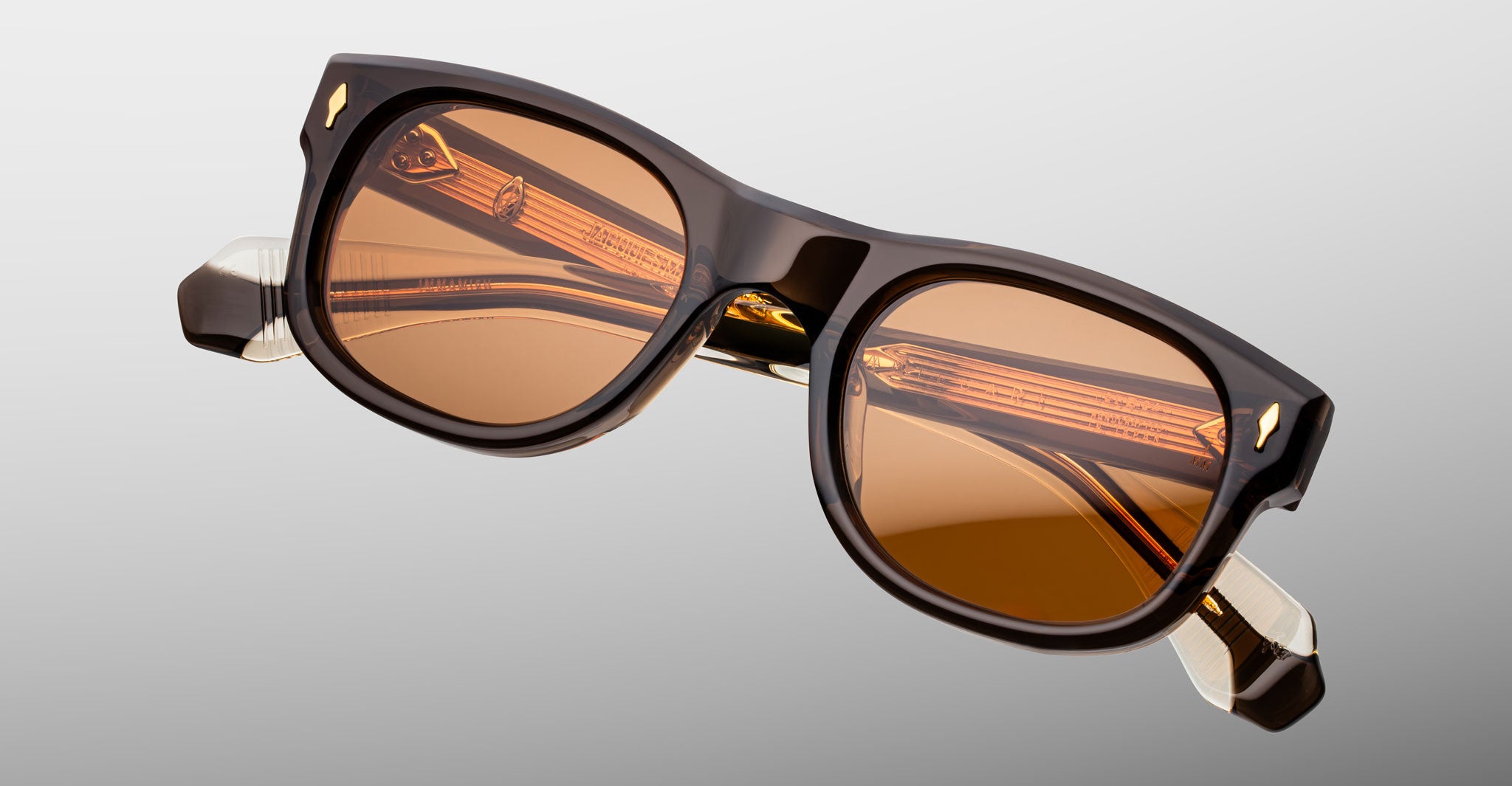 Jacques Marie Mage Amilcar sunglasses, brown acetate frame, amber lenses, gold accents, visible hinges, front view.