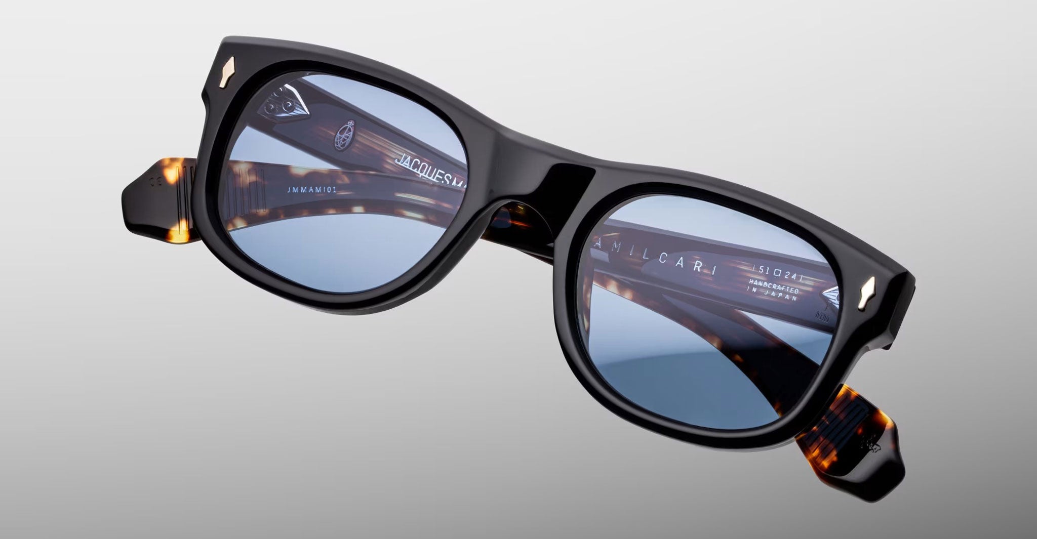 Jacques Marie Mage Amilcar sunglasses, black square frames, blue lenses, tortoiseshell-accented arms, front angle.
