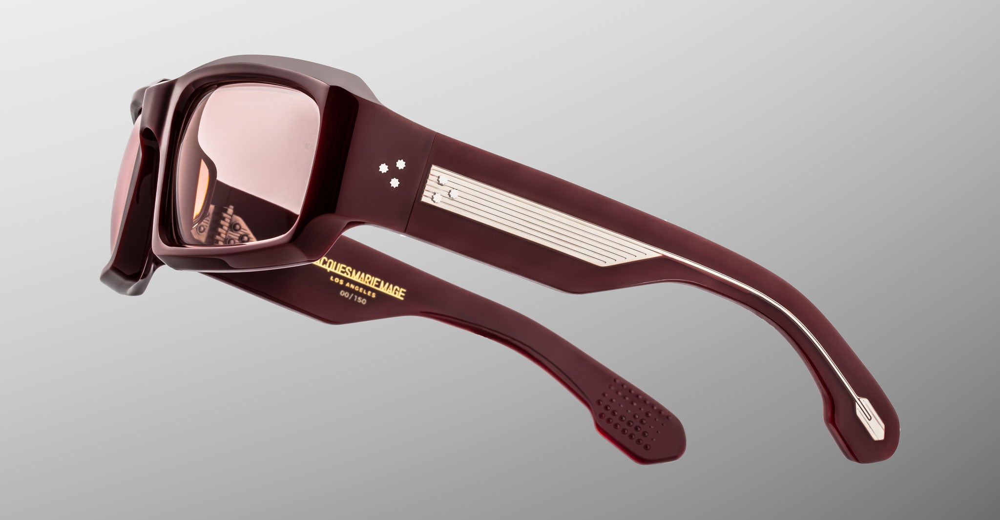 Side view of Jacques Marie Mage Apollo in Bordeaux Empire featuring a bold rectangular burgundy acetate frame, wide sculpted temple with exposed engraved metal core, triple dot rivets, signature arrowhead tip, and rose-tinted lens.