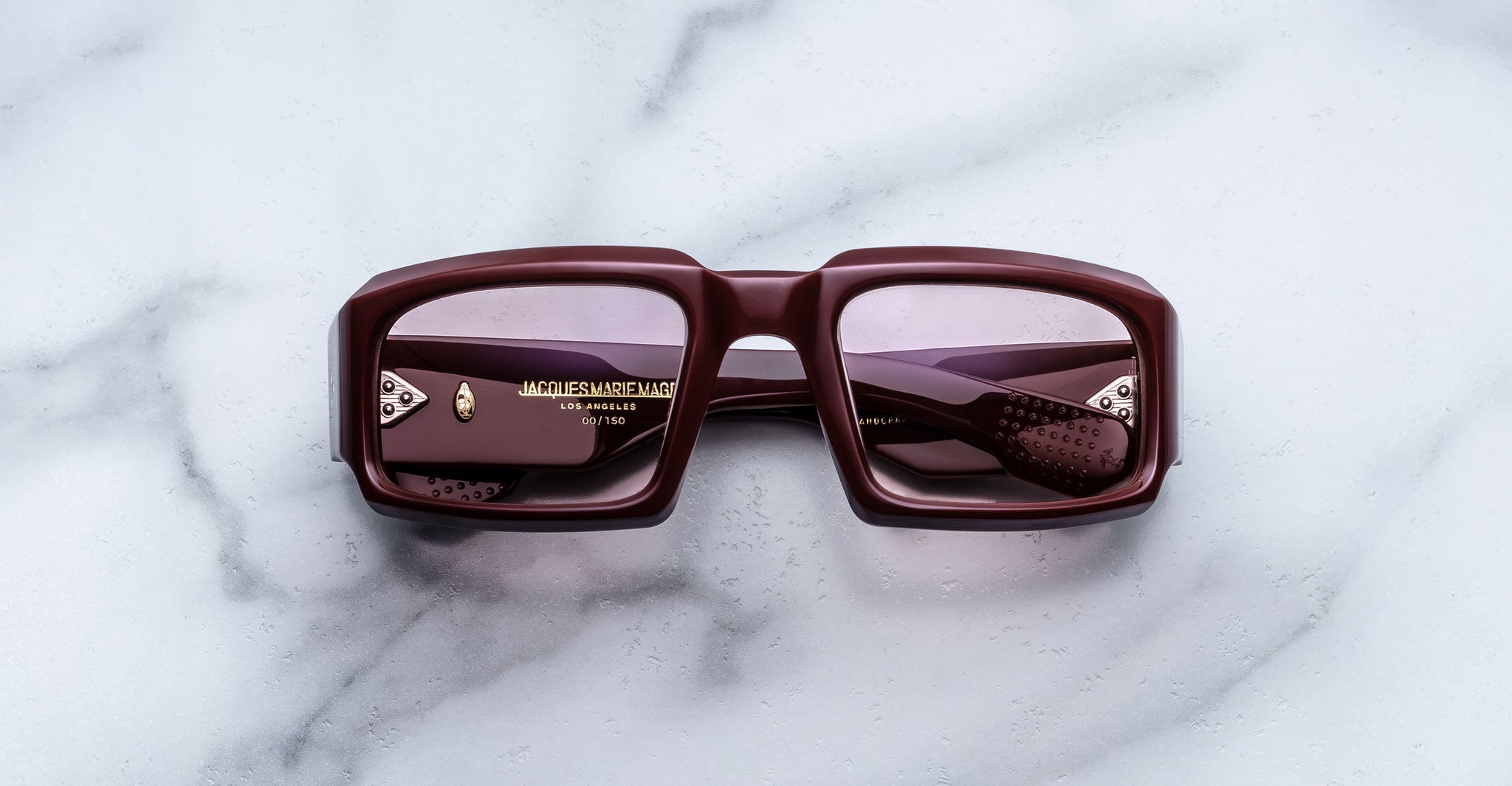 Front view of Jacques Marie Mage Apollo in Bordeaux Empire featuring a bold rectangular frame in deep burgundy acetate, thick sculpted rims, rose-tinted lenses, and hinge hardware visible through the lens.