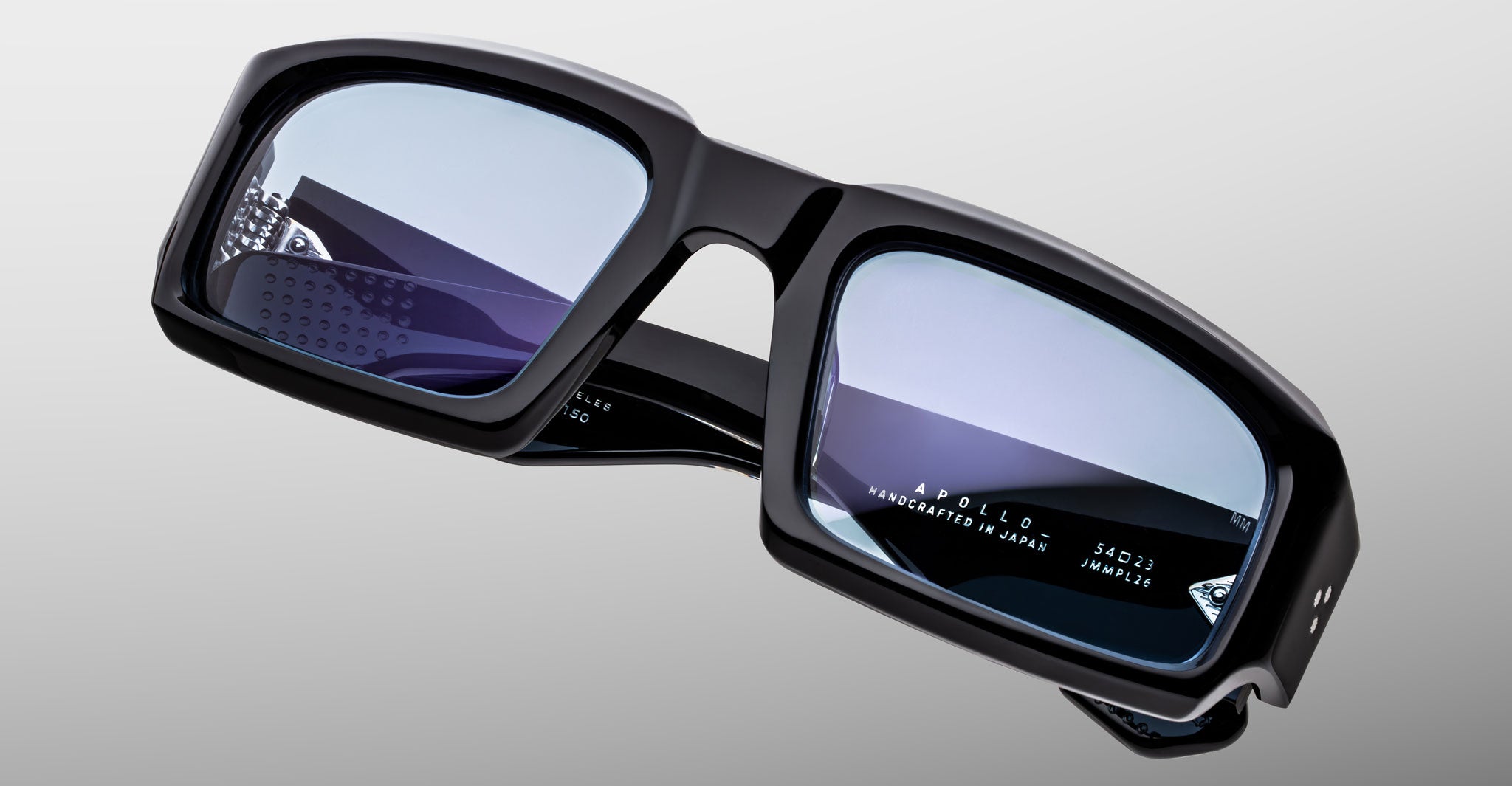 Jacques Marie Mage Apollo in Shadow acetate frame with a bold rectangular silhouette, deep black high-gloss finish, thick sculpted rims, and blue-tinted lenses featuring subtle internal engraving and signature arrowhead details at the temples.