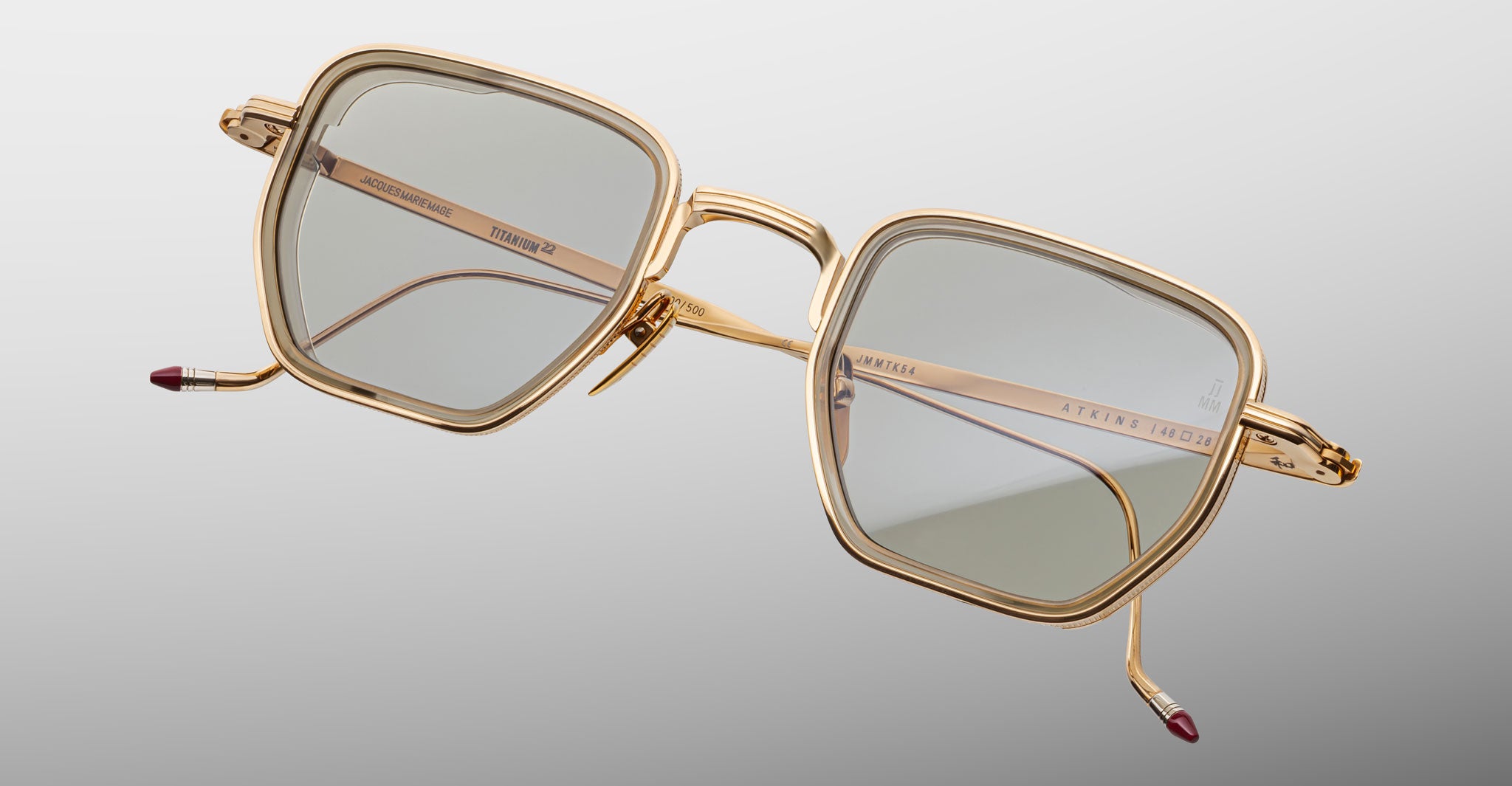 Jacques Marie Mage Atkins eyeglasses with gold square frames and light-tinted lenses, shown from the front.