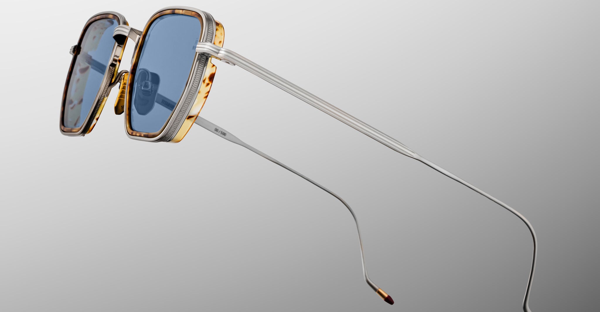 Jacques Marie Mage Atkins rectangular sunglasses, blue lenses, gold-accented frames, thin silver metal arms; front angle view.