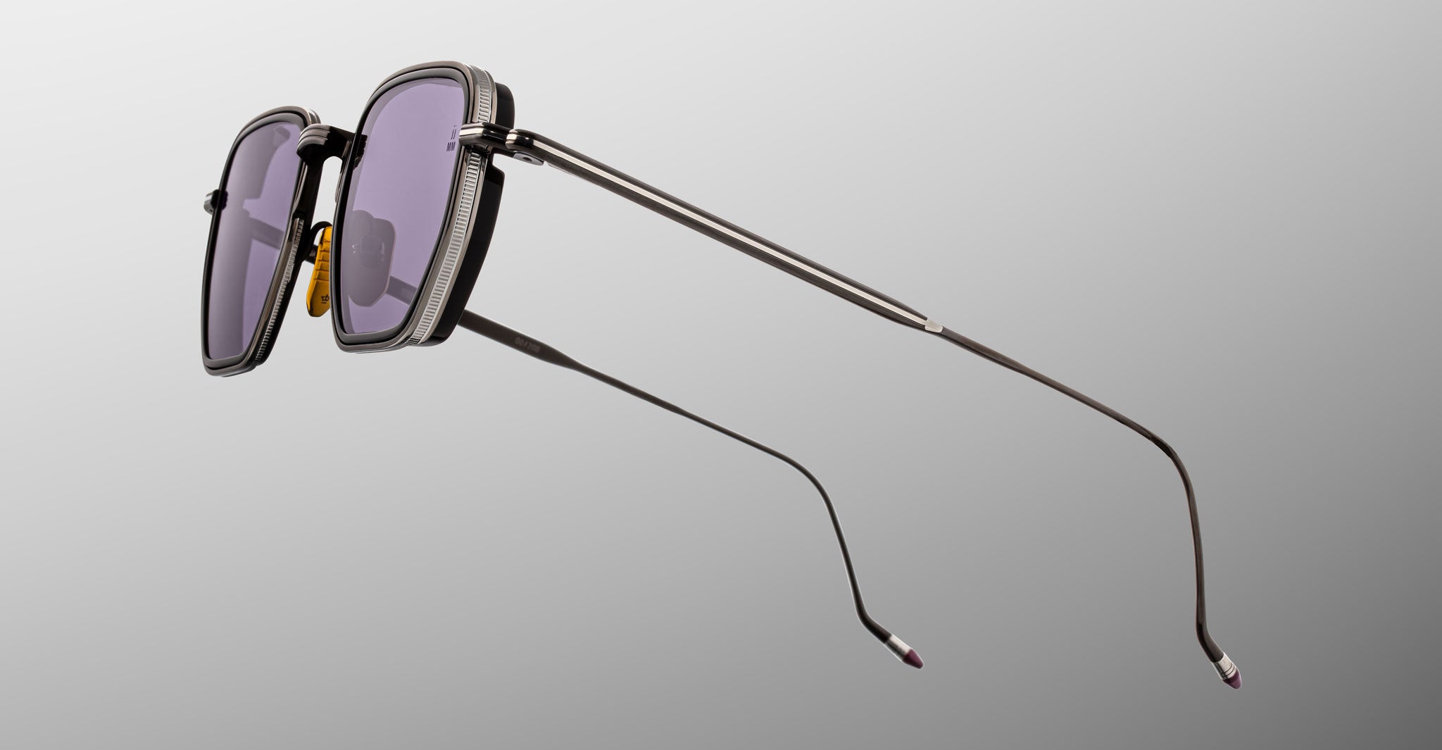 A pair of Jacques Marie Mage Atkins sunglasses, featuring a stylish rectangular design with dark lenses and slim metal arms, shown in a side profile against a plain gray background.