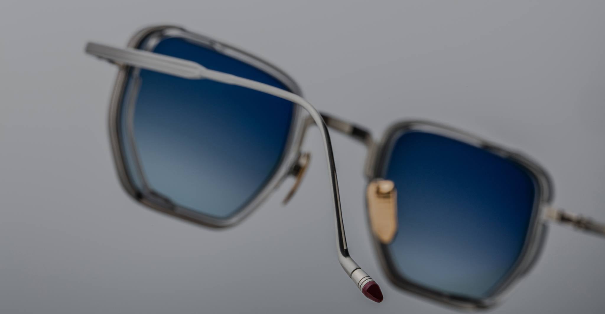 Close-up of Jacques Marie Mage Atkins eyeglasses, showing blue gradient lenses and silver frames, front-facing view.