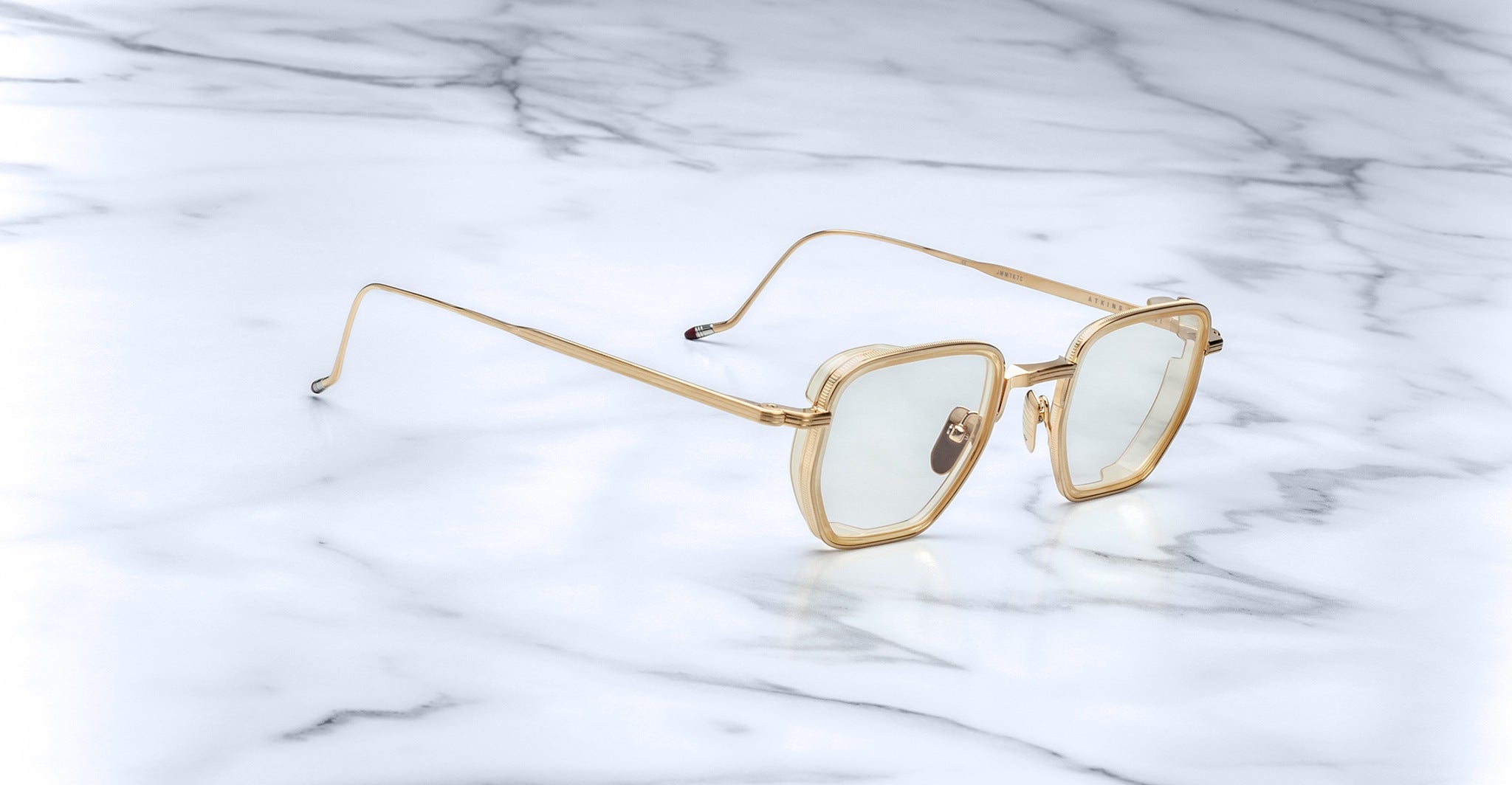 Jacques Marie Mage Atkins gold-framed sunglasses with light tinted lenses, shown from above.
