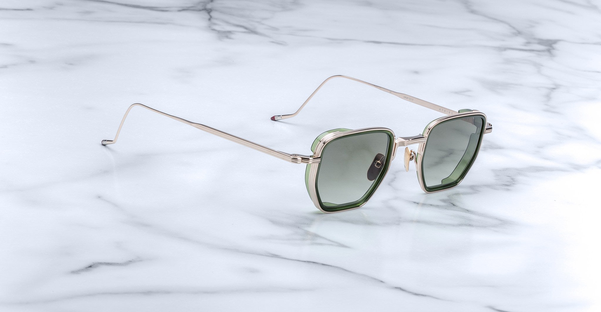 Jacques Marie Mage Atkins sunglasses, heart-shaped green lenses with gold frames, top-down view.