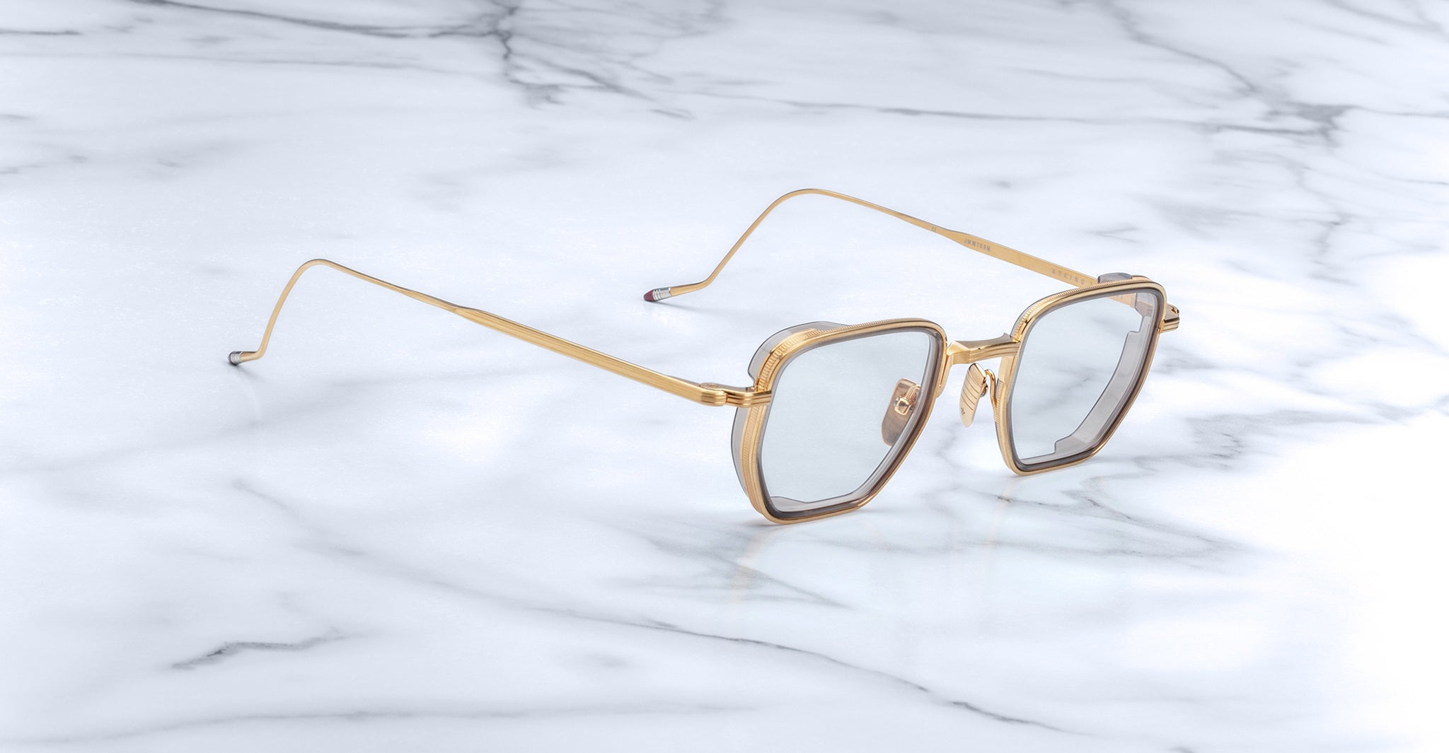 Jacques Marie Mage Atkins square sunglasses with gold rims and light gray lenses, front angle.