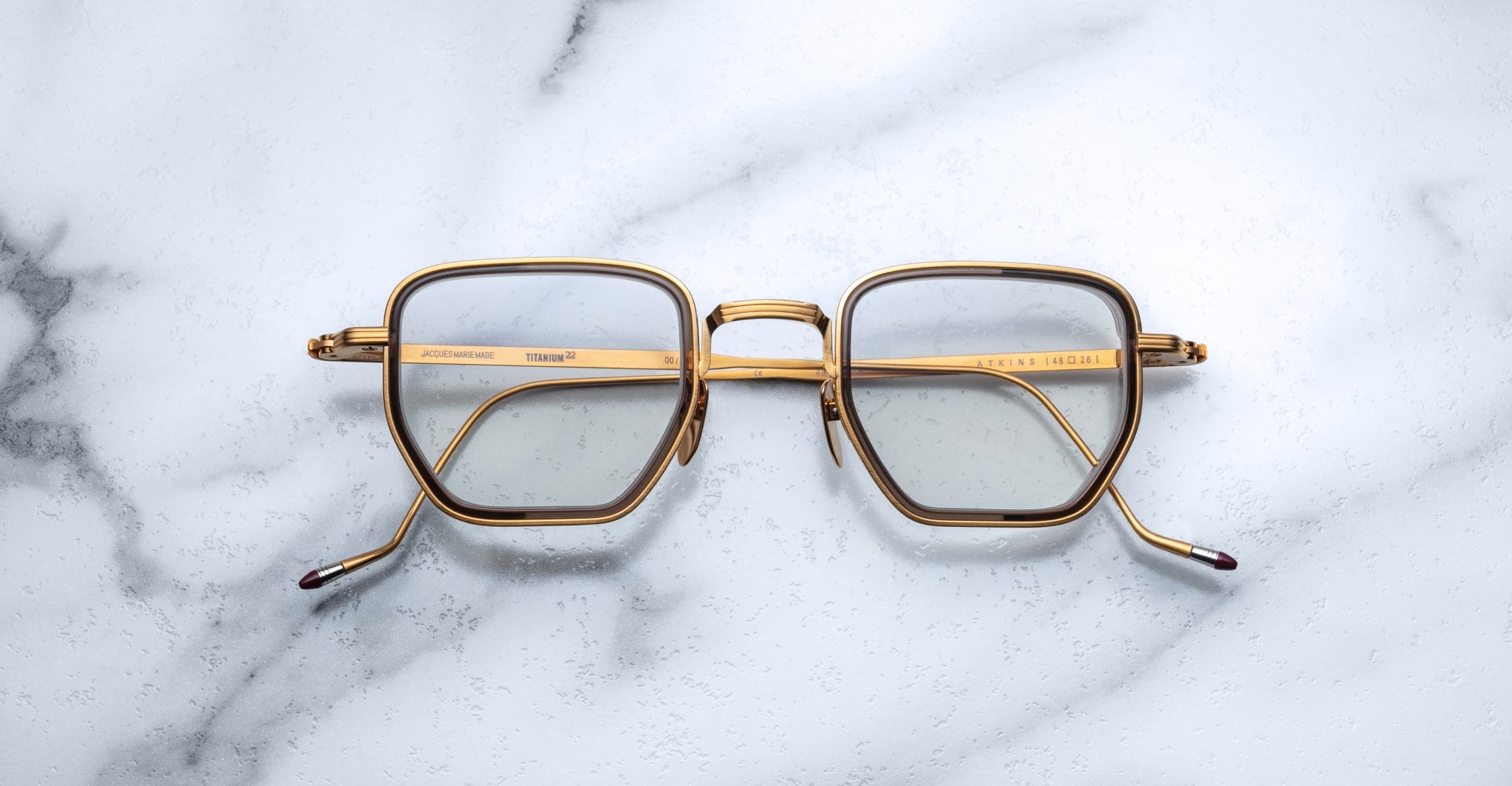 Jacques Marie Mage Atkins eyeglasses with gold geometric frames and angular lines, front view.