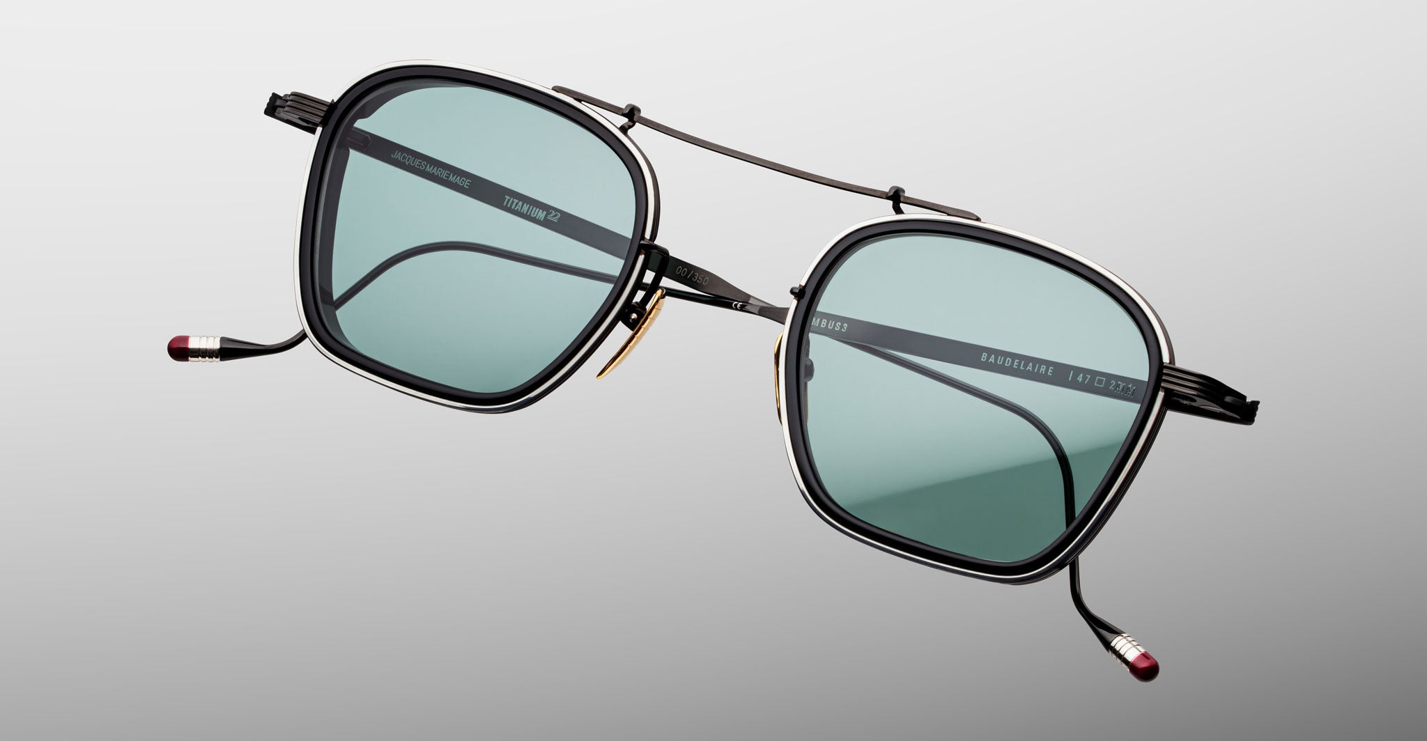 Jacques Marie Mage Baudelaire 2 sunglasses, black square frames, blue-tinted lenses, metallic accents, front view.