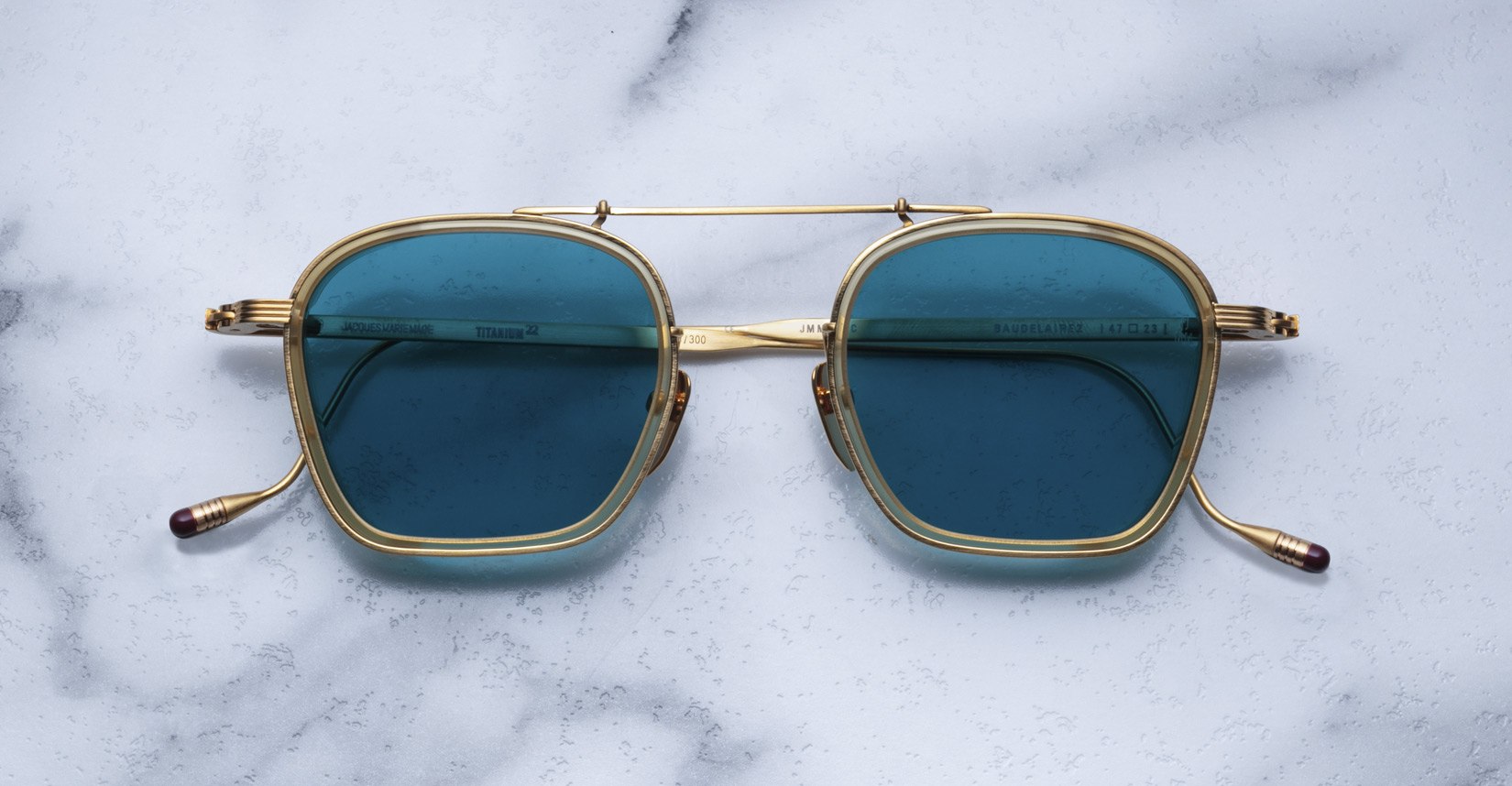 Jacques Marie Mage Baudelaire 2 gold square sunglasses with blue UV lenses, top view.