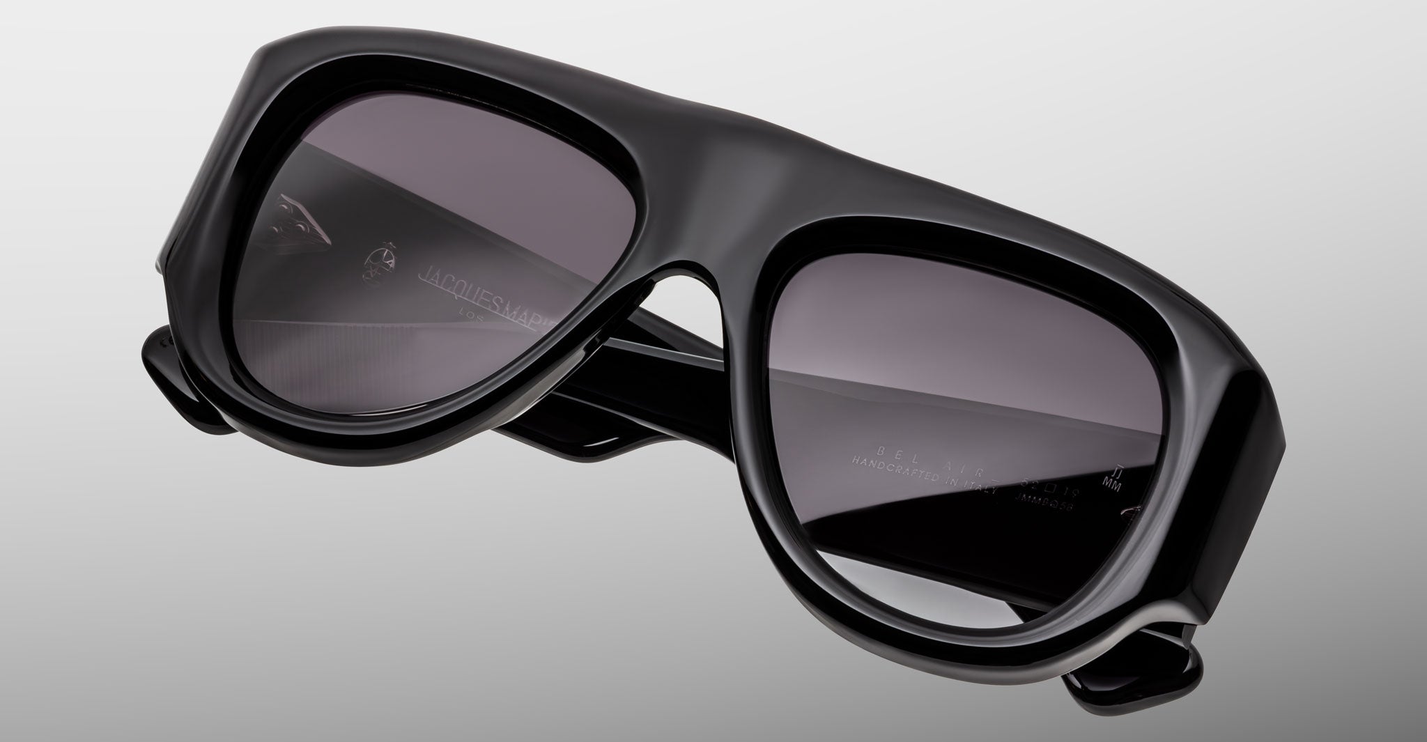 The Jacques Marie Mage Bel Air, a pair of oversized black sunglasses with thick frames and dark tinted lenses, is displayed against a plain, light gray background.