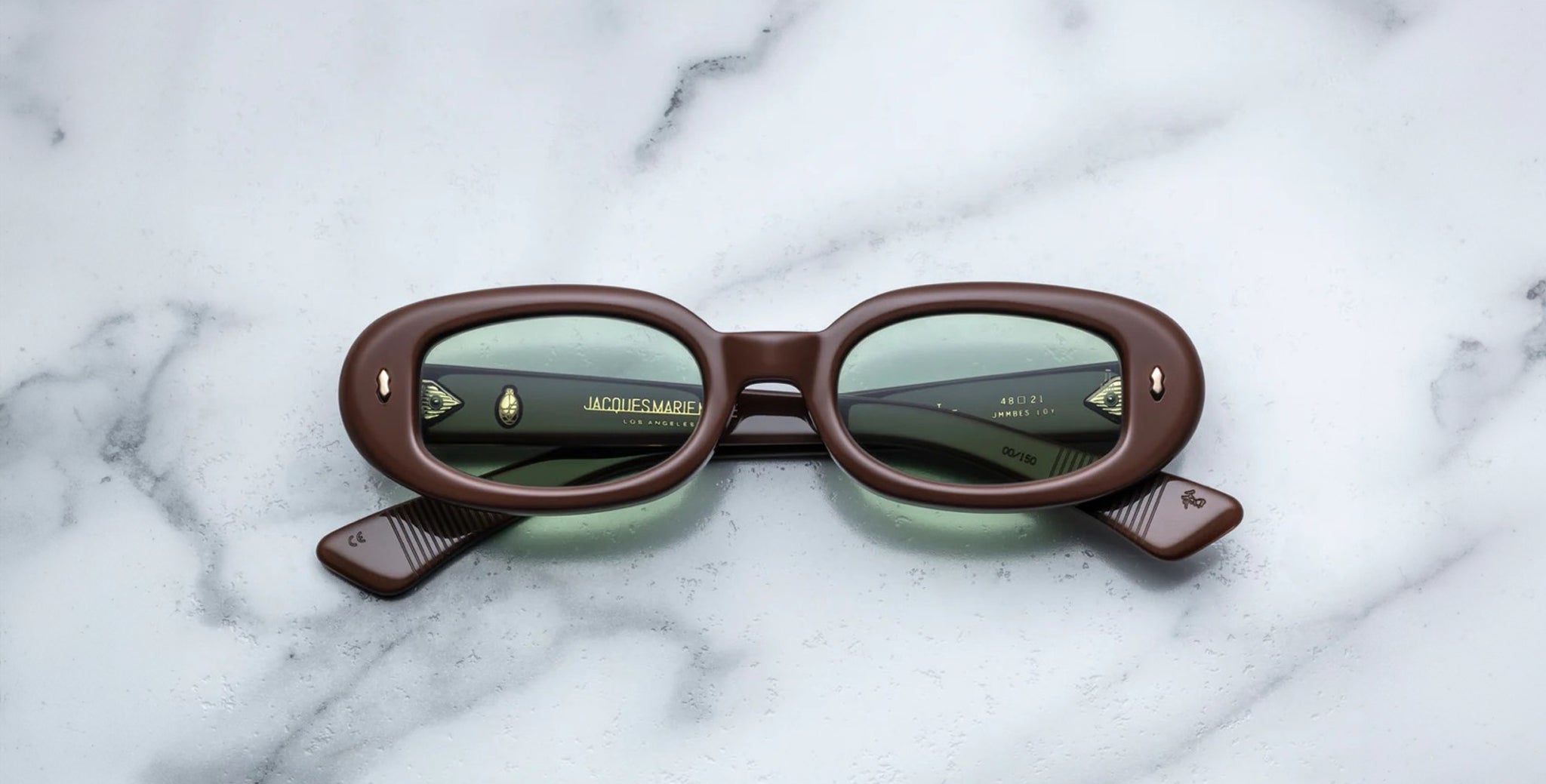 Jacques Marie Mage Besset brown oval sunglasses with green UV-protective lenses, top view.