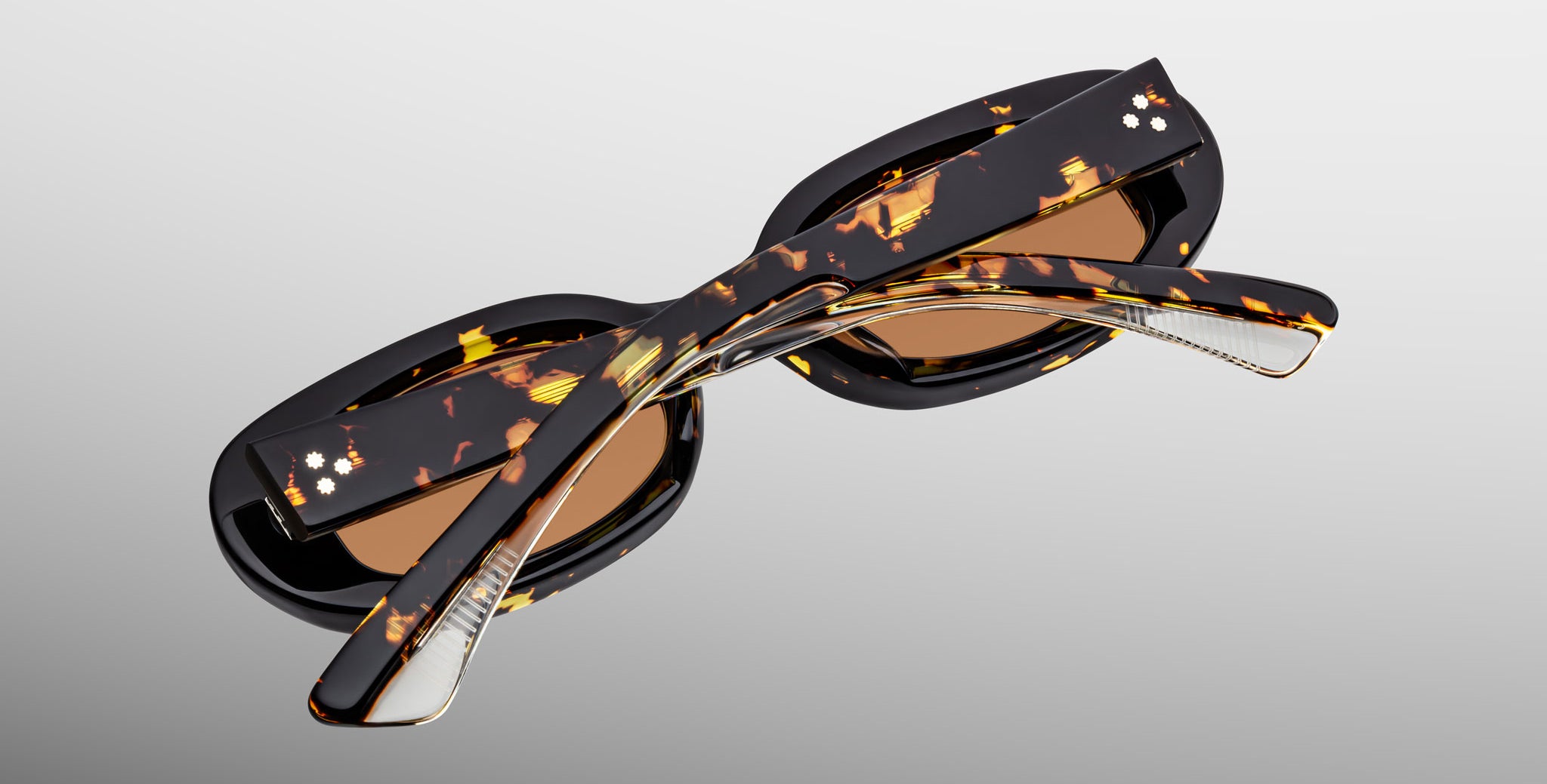 Jacques Marie Mage Besset sunglasses in brown and yellow tortoise shell pattern with orange lenses close-up back view with folded temples