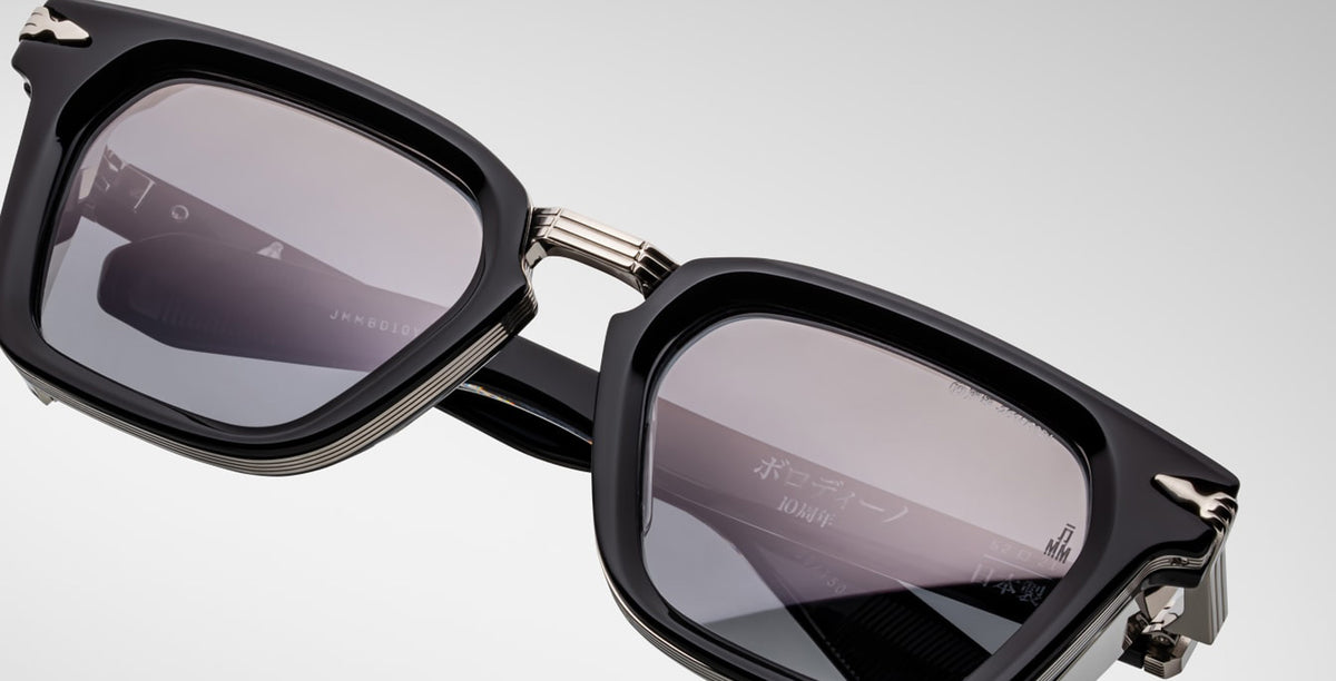 Close-up of Jacques Marie Mage Borodino rectangular black sunglasses with dark UV lenses and silver hinge accents.