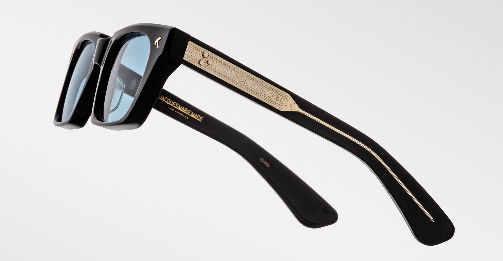 Jacques Marie Mage Quentin sunglasses, black frame with blue lenses and gold arm accents, shown from rear side angle.