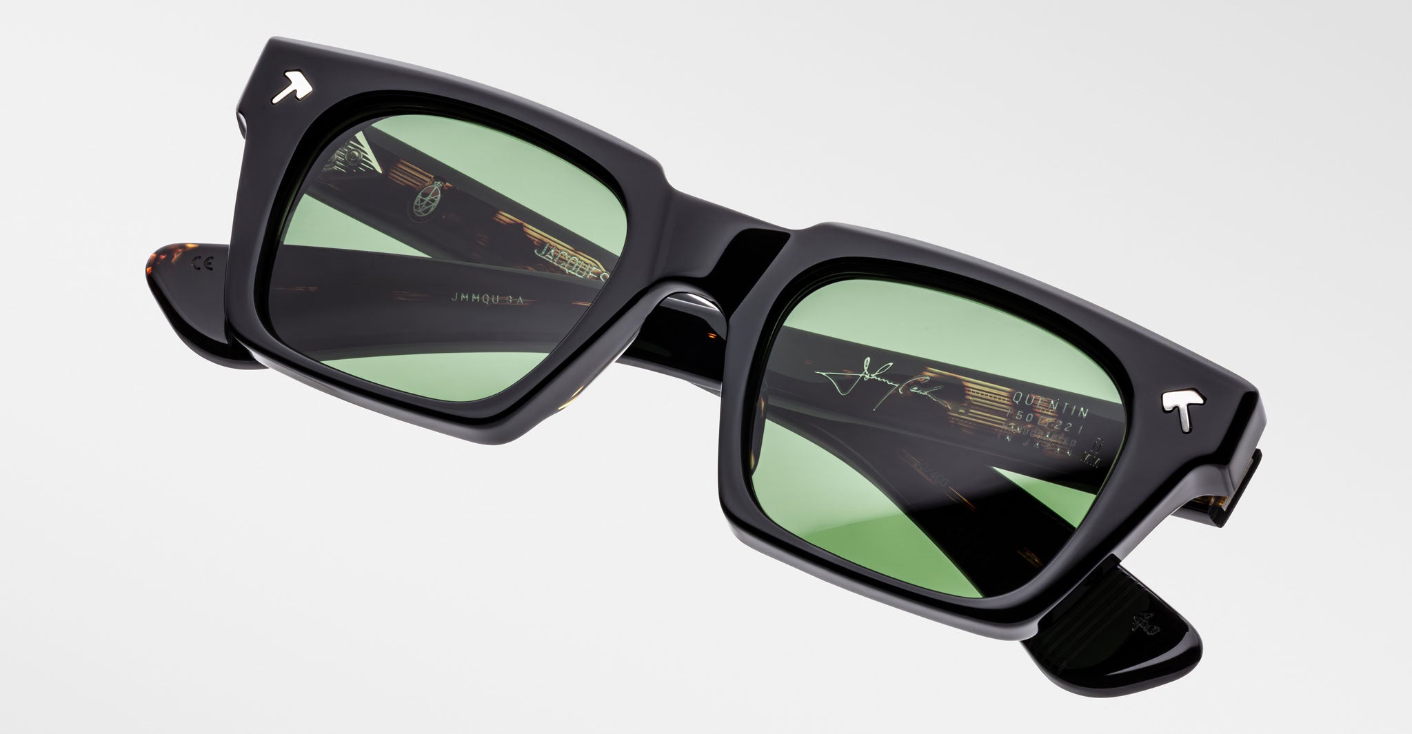 Jacques Marie Mage Quentin sunglasses, black square frames with green lenses, white logos at corners, front-facing view.