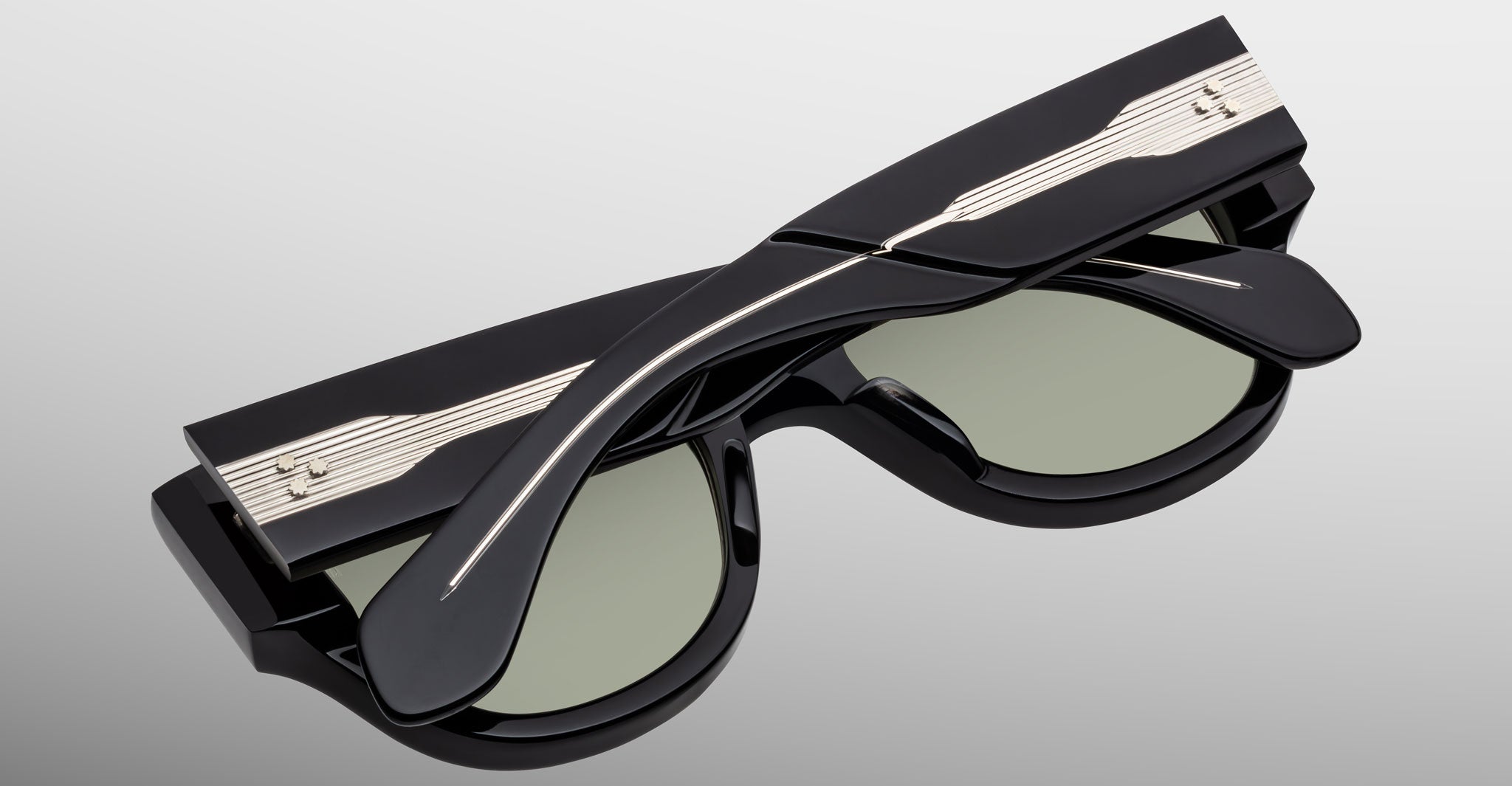 The Jacques Marie Mage Chelsea sunglasses are shown folded, featuring metallic music staff and note details on the temples, set against a light gray background.