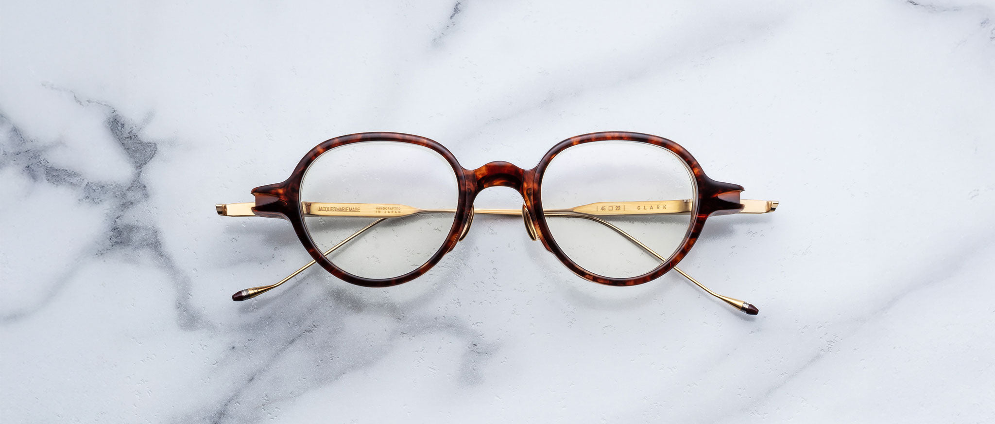 Jacques Marie Mage The Clark round tortoiseshell eyeglasses with gold arms, top view.