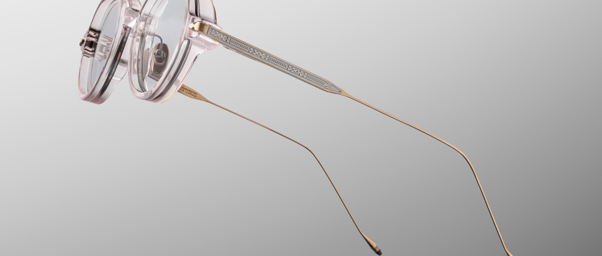 Jacques Marie Mage The Clark eyeglasses with round, translucent pink frames and thin gold temples, front angle view.