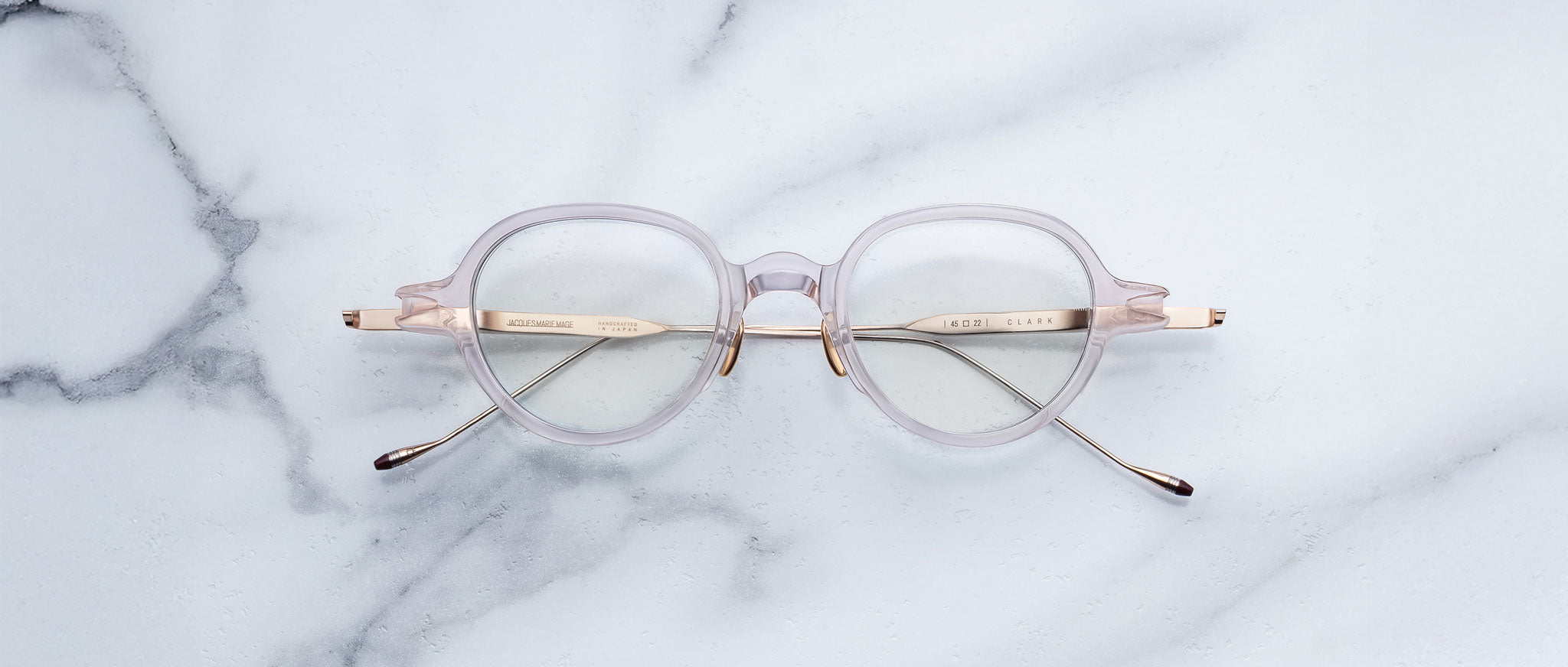 Jacques Marie Mage The Clark round eyeglasses with gold arms, shown from above, featuring minimalist design.